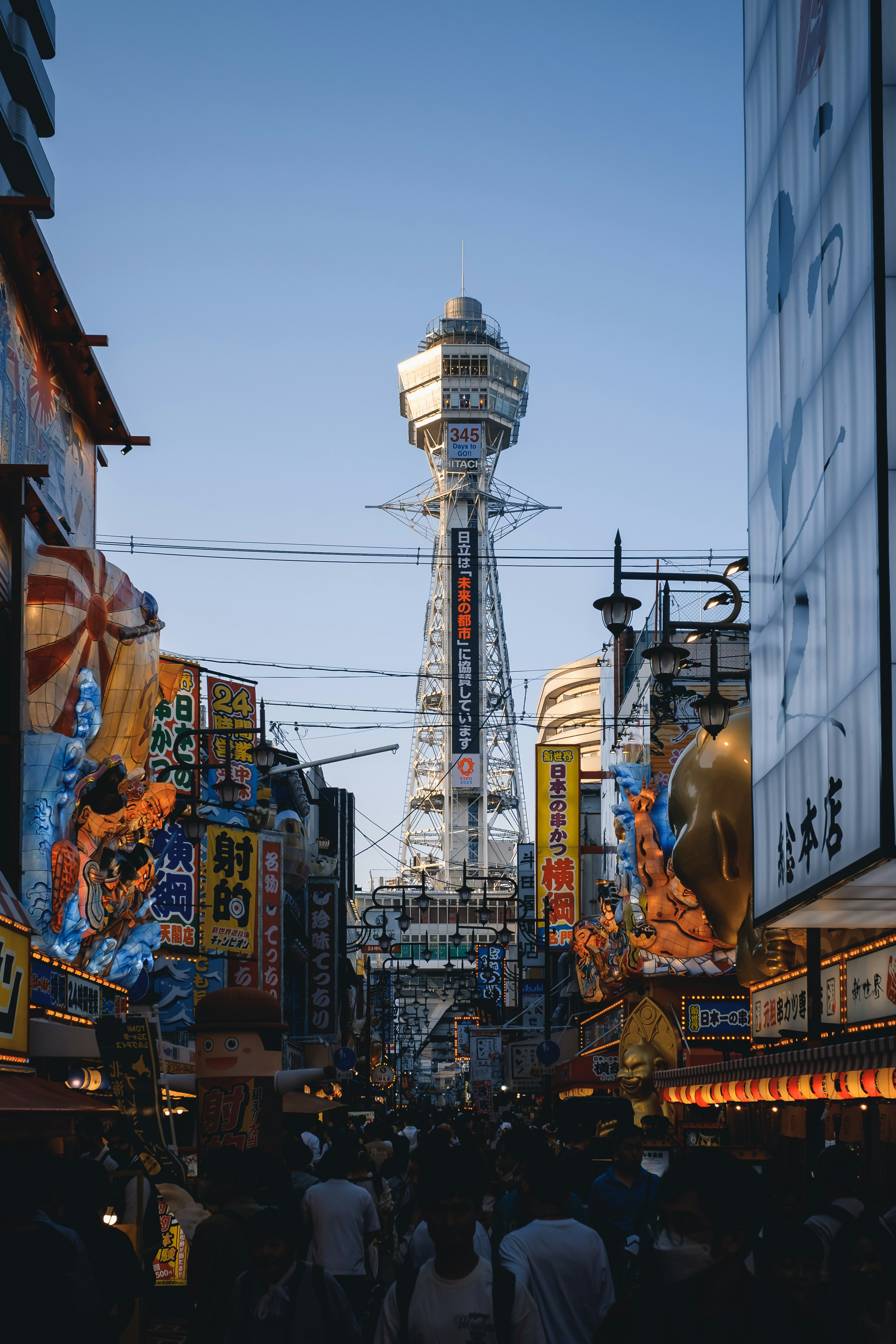 A crowded city street with a tall tower in the background