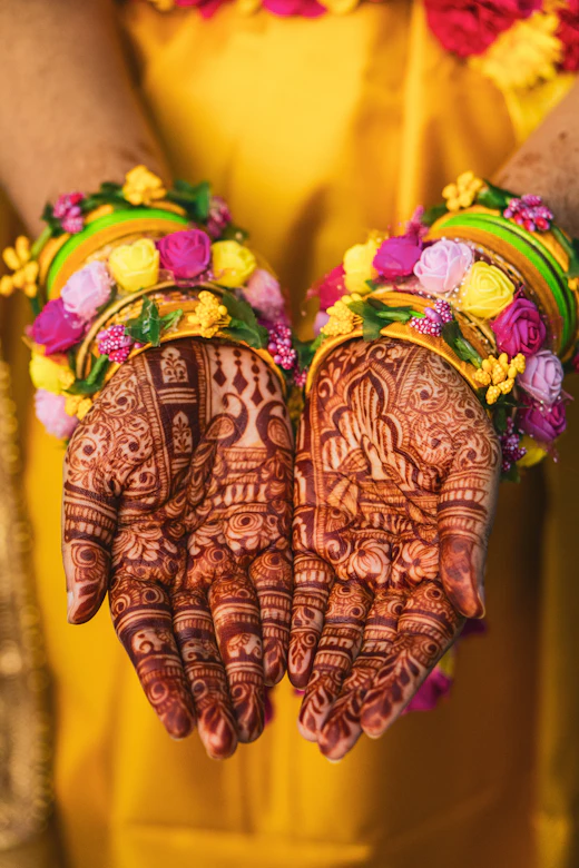 Hands with bridal mehendi holding floral jewellery