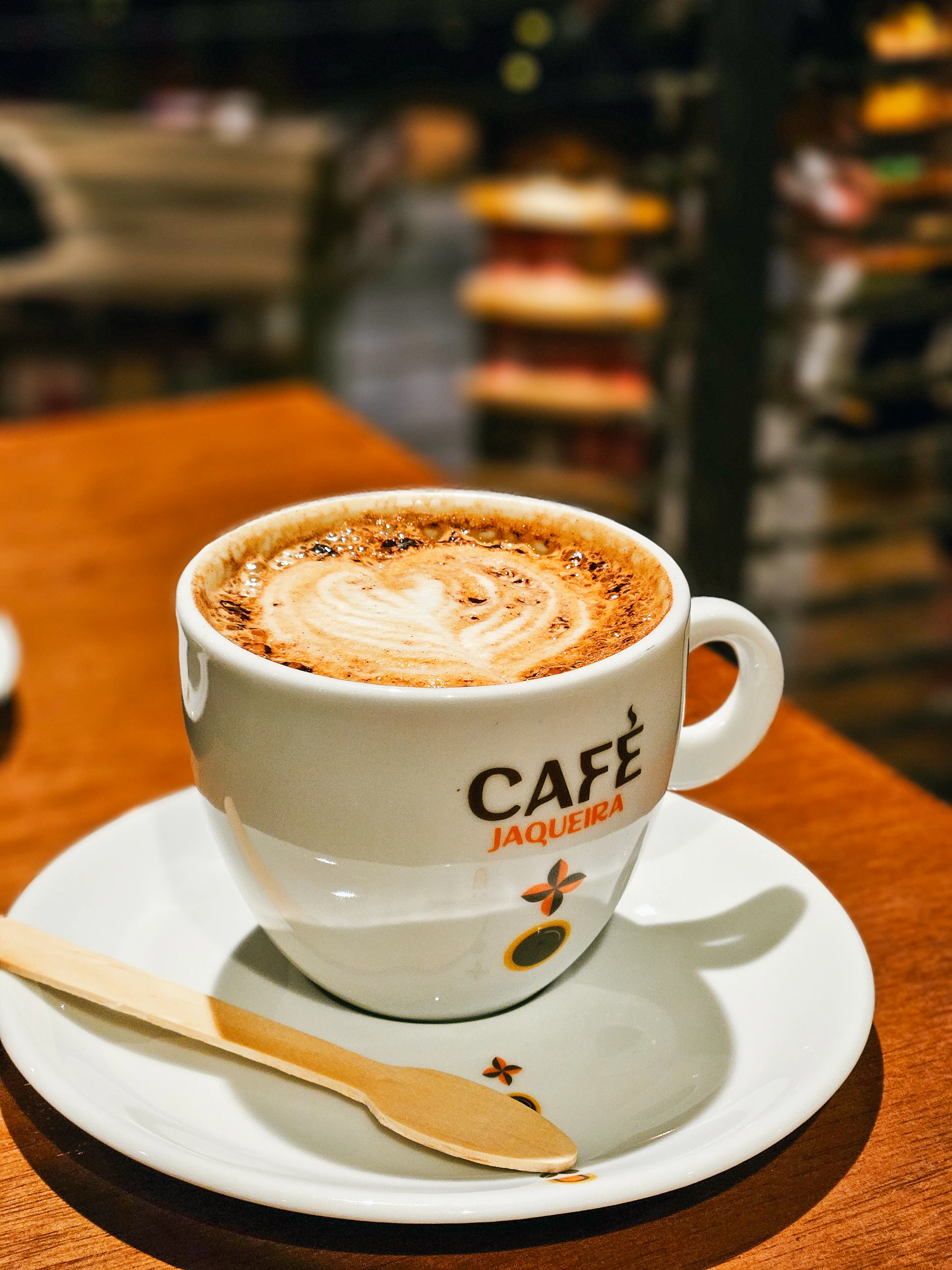 A cup of cappuccino on a saucer on a table
