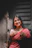 A woman in a red sari standing in front of a door