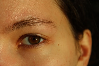 A close up of a woman's face with a brown eye