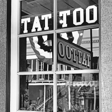 A store window with a tattoo sign in it