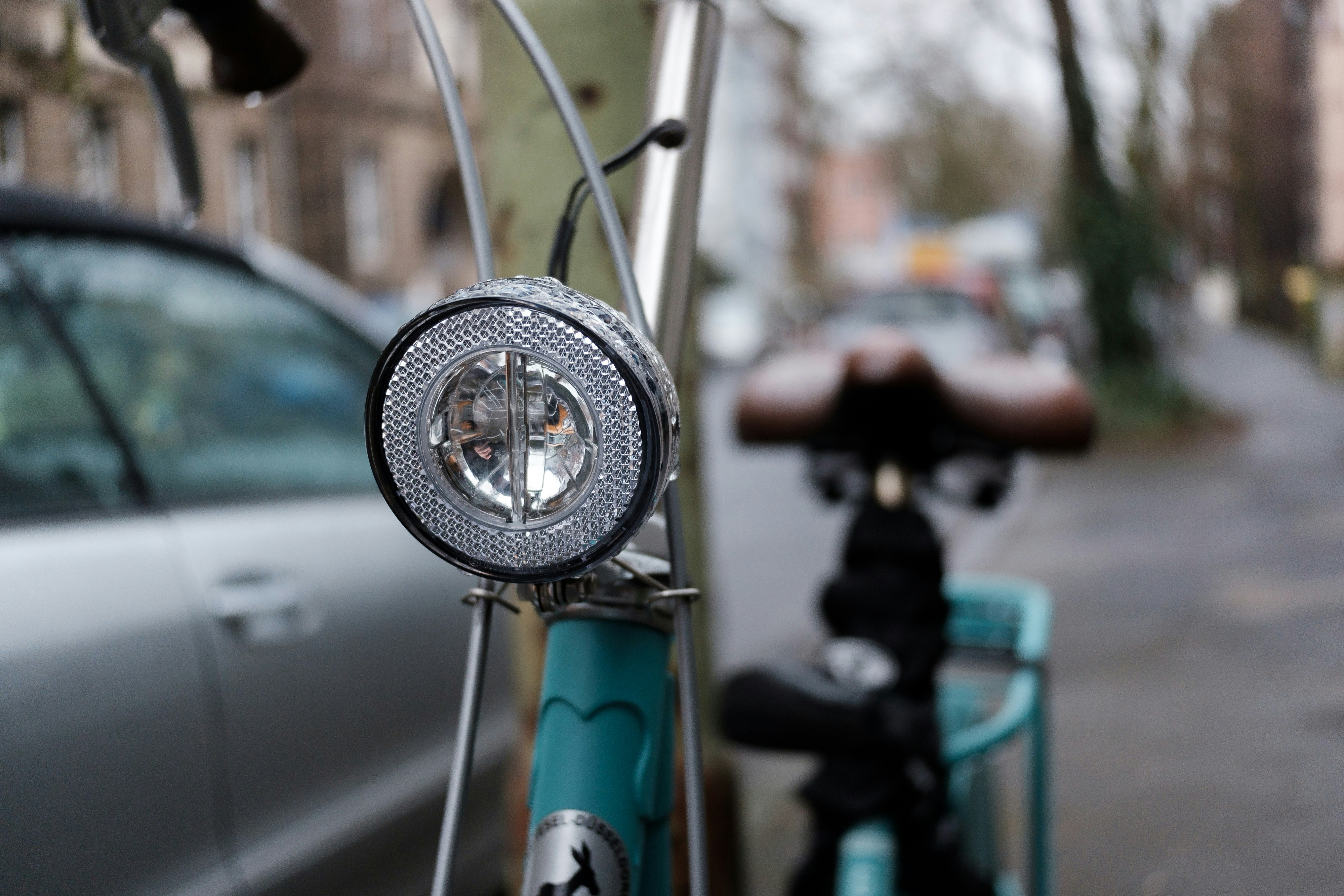 A bicycle parked next to a car on a street