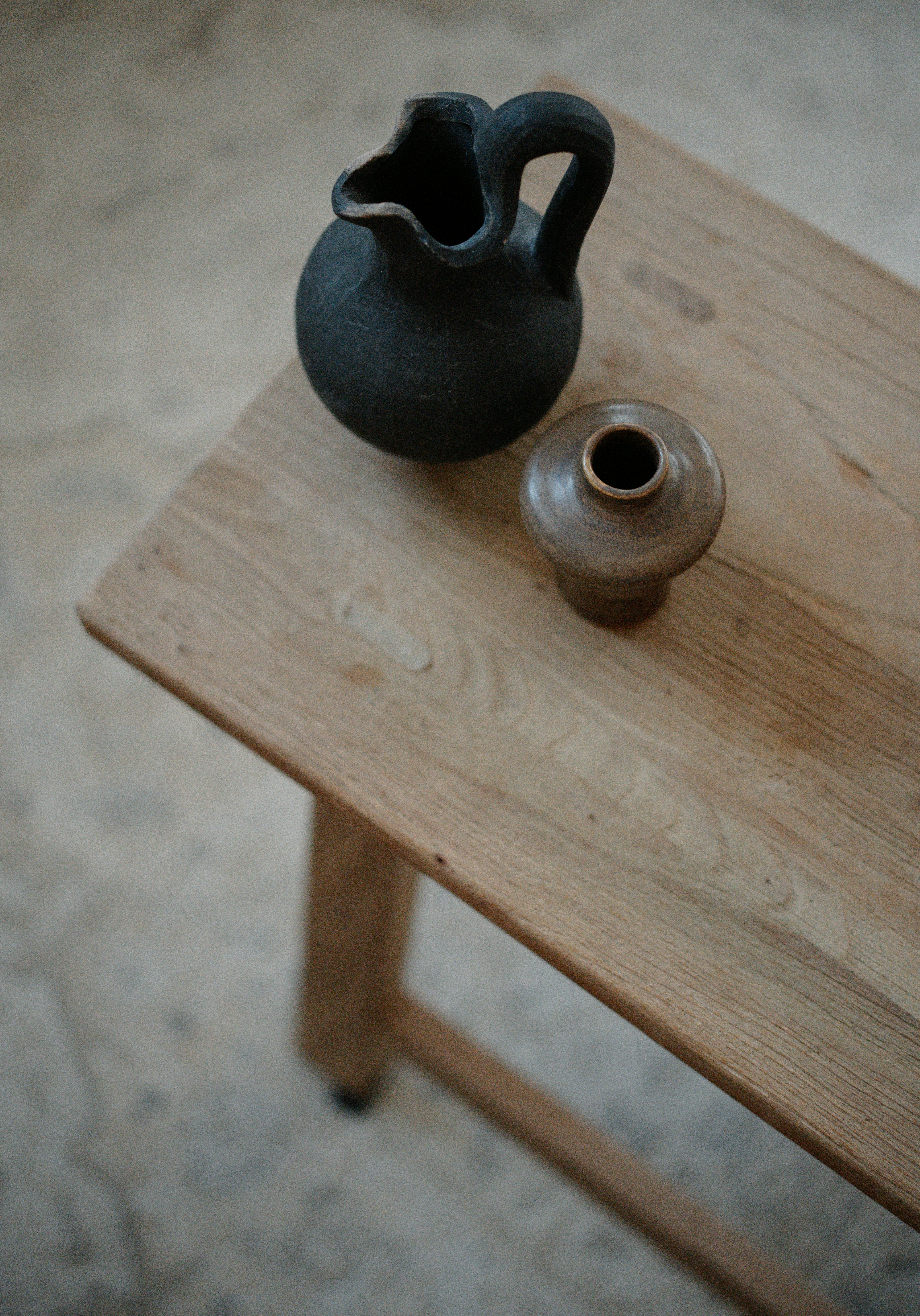 A black vase sitting on top of a wooden table