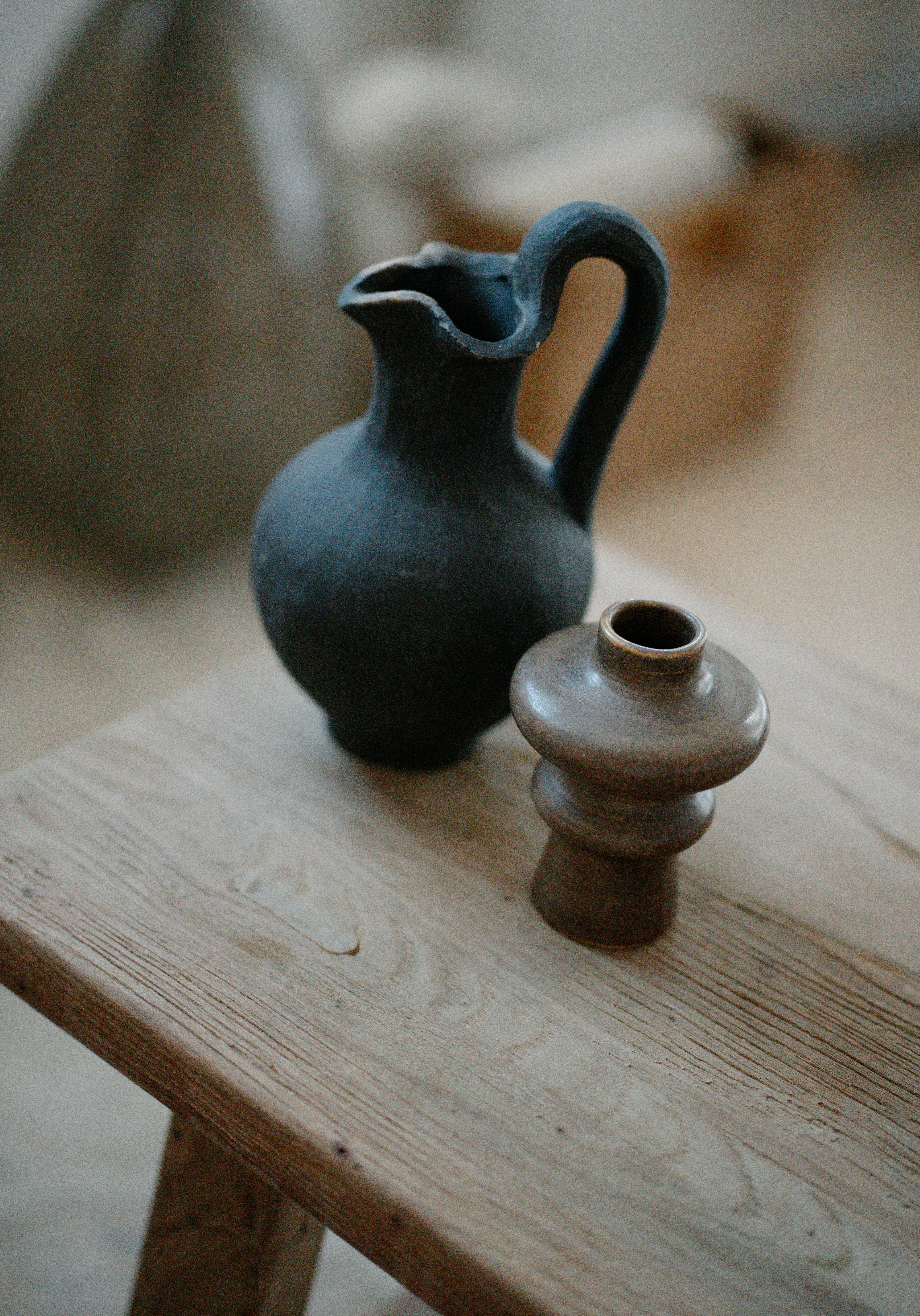 Two vases sitting on a wooden table next to each other