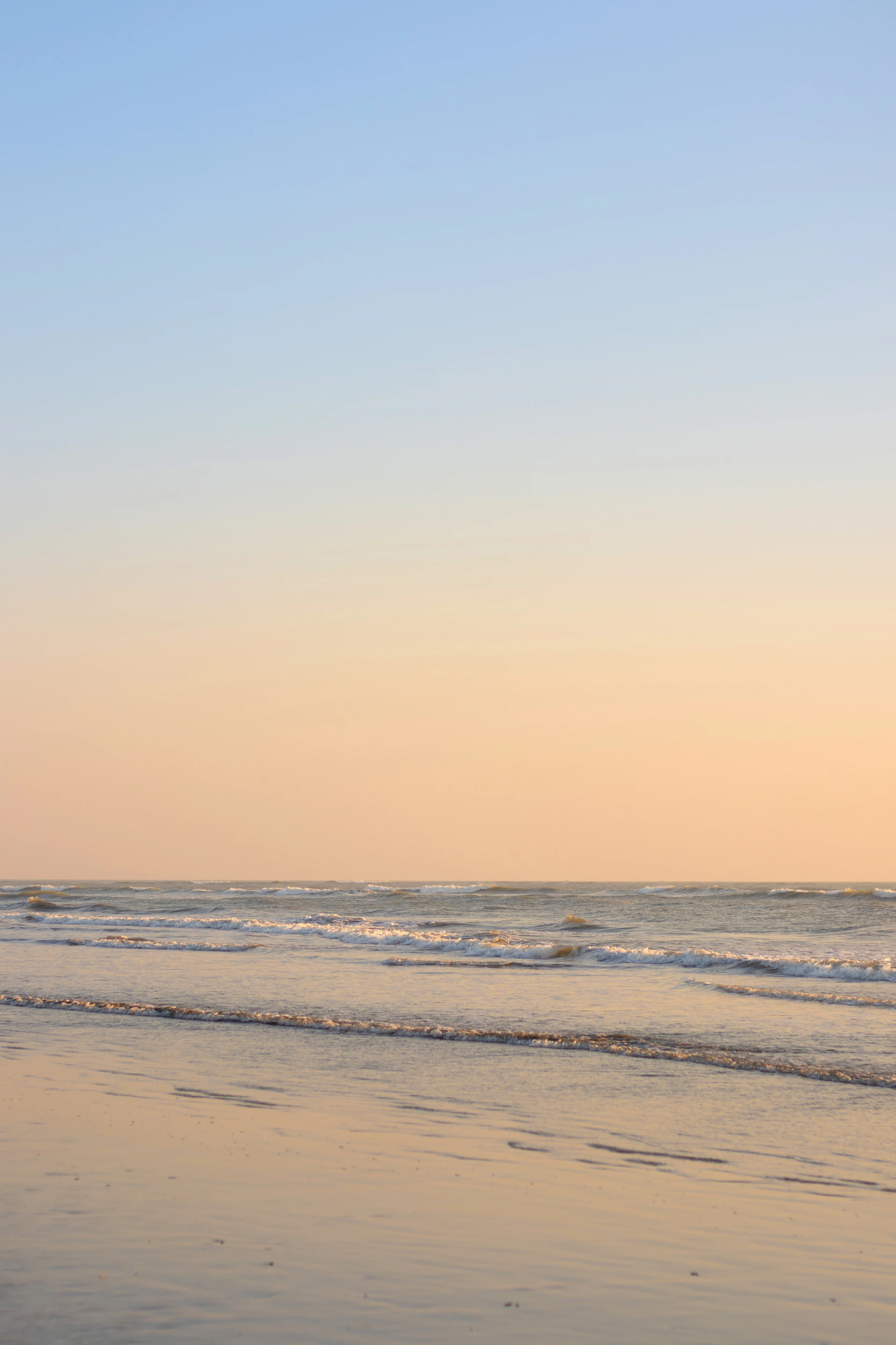 A person walking on the beach with a surfboard