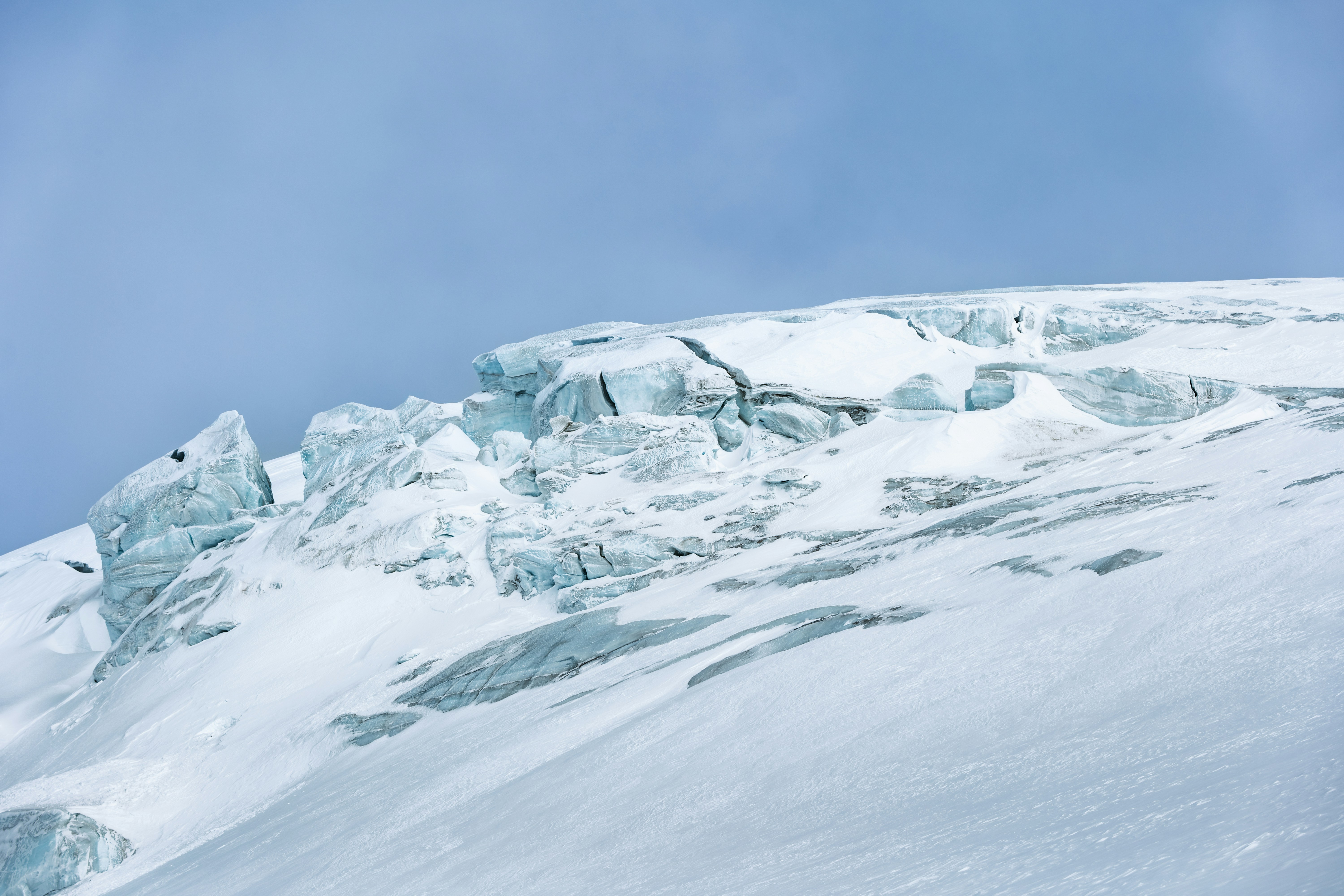 A man riding skis down the side of a snow covered slope