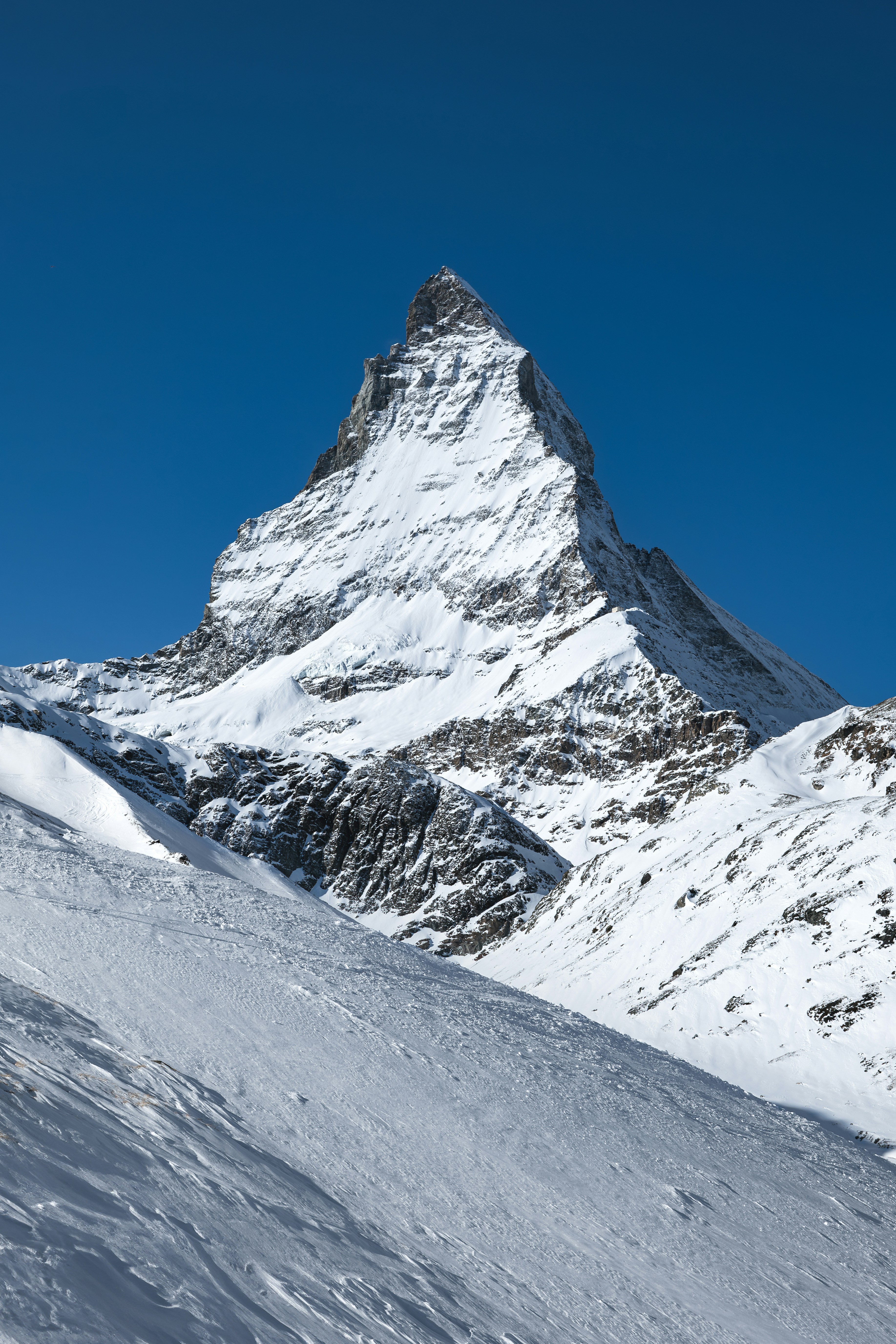 A man riding skis down the side of a snow covered slope