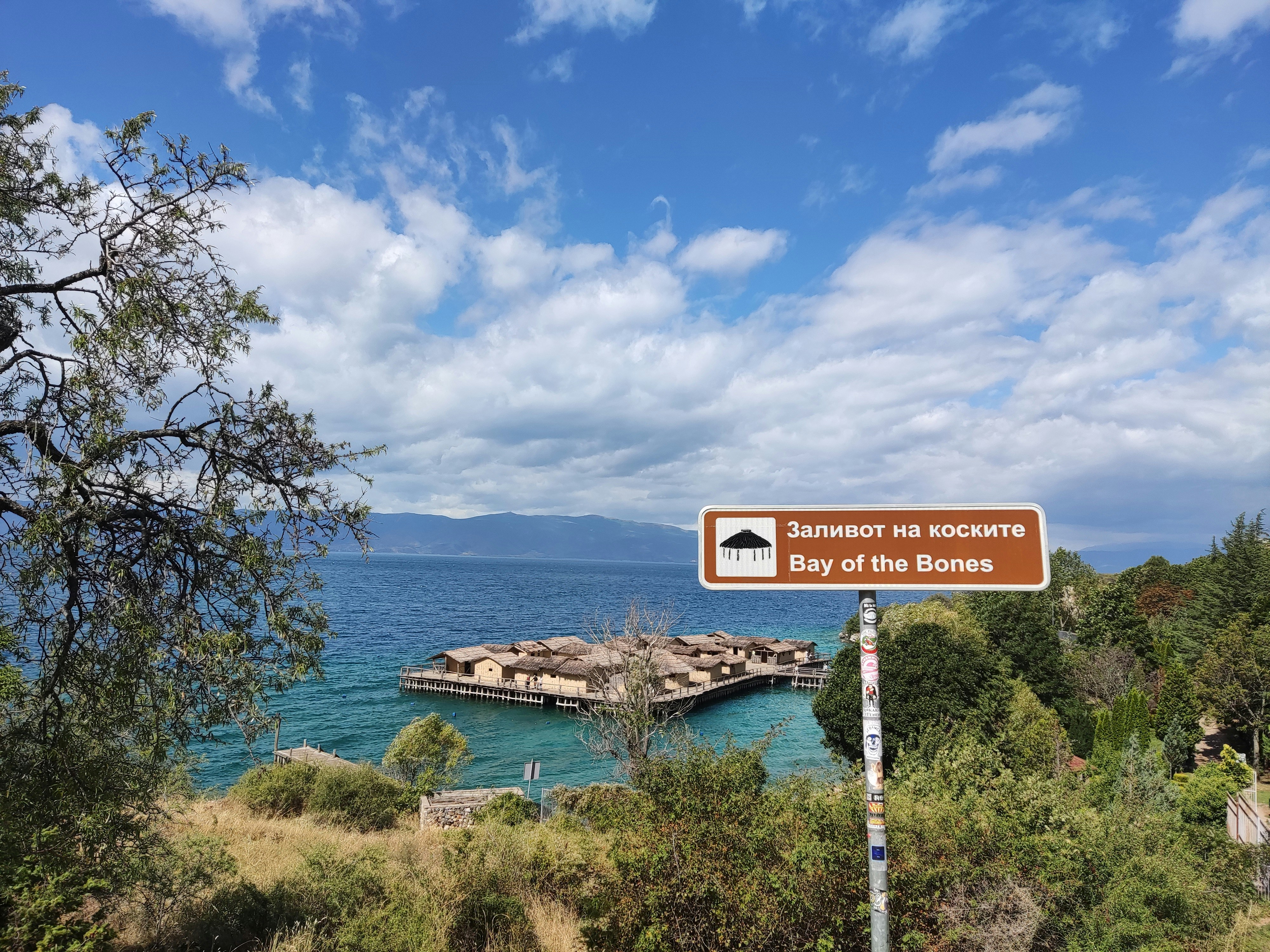 A sign that is on the side of a hill, Macedonia – The Bay of Bones, a stunning historical site on the beautiful Ohrid Lake.