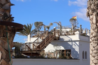 A white building with a staircase going up the side of it