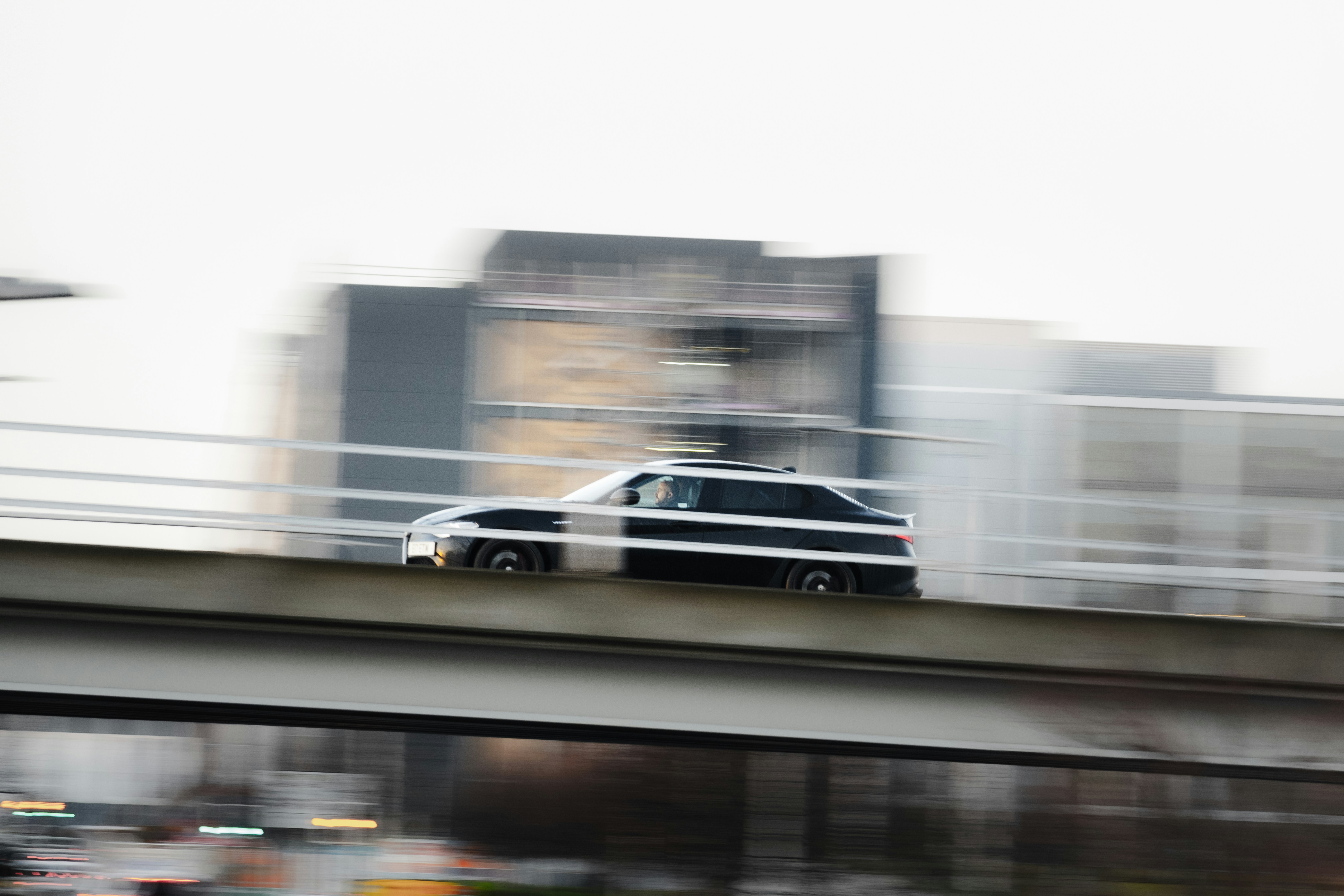 A car driving over a bridge in a city
