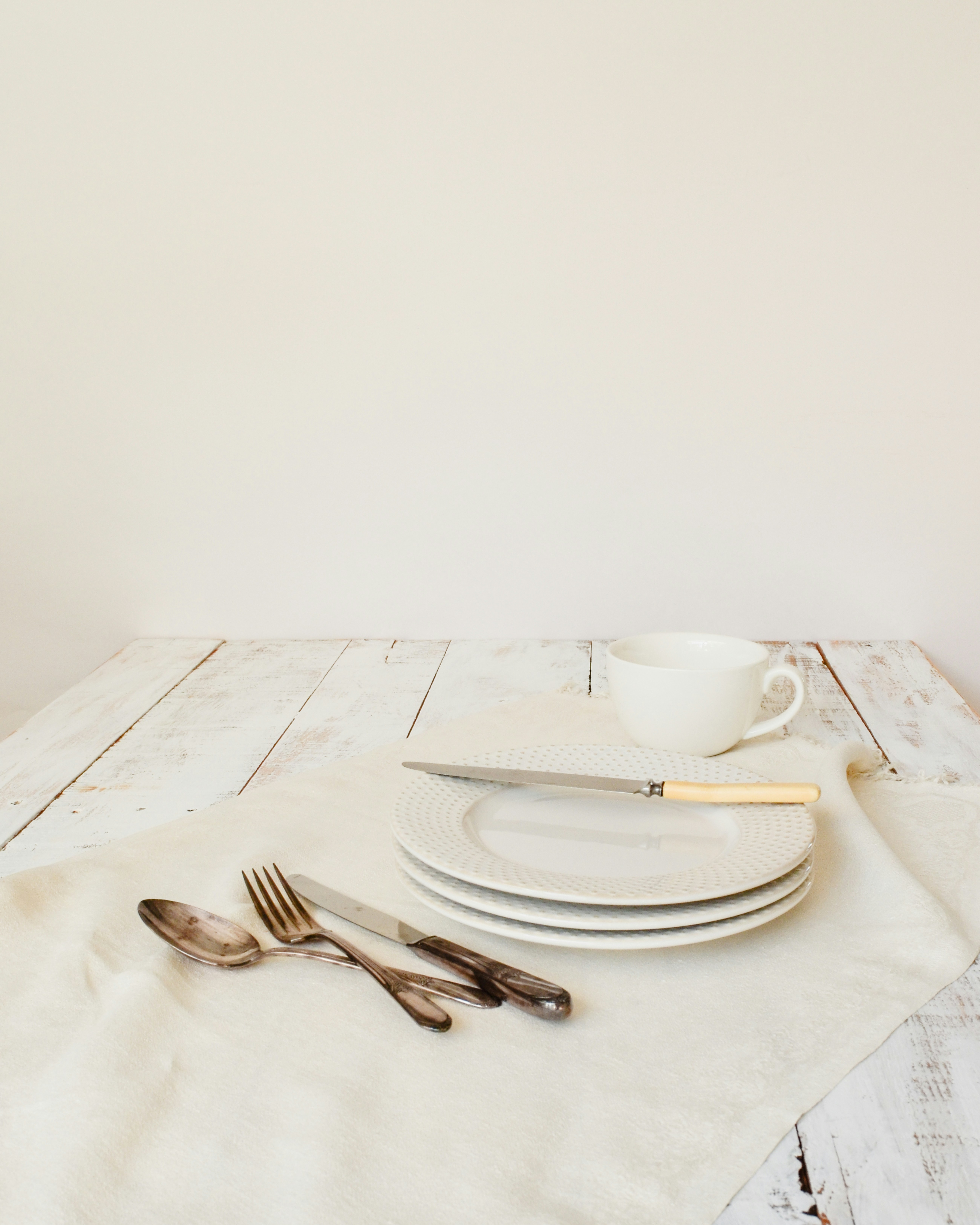 A white table topped with plates and silverware