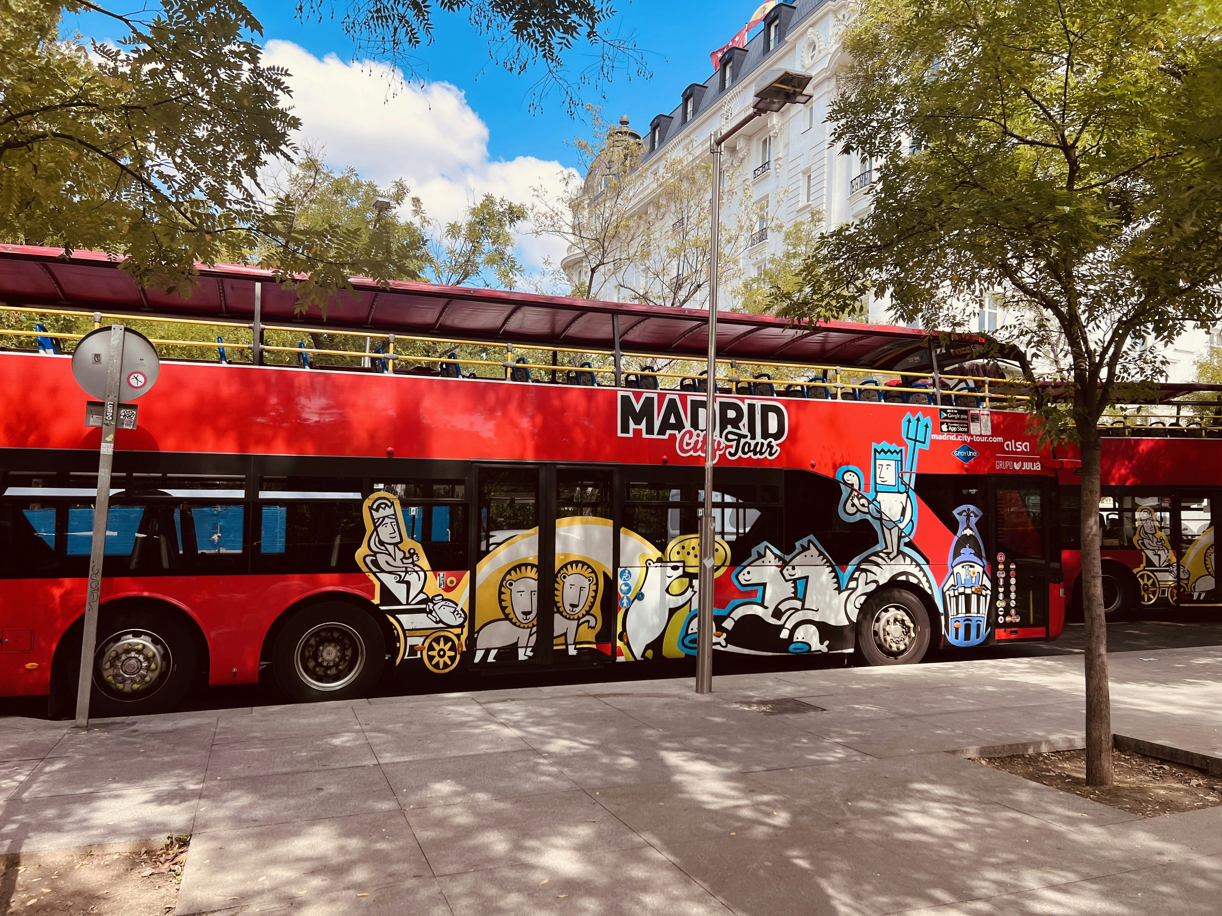 A red double decker bus parked on the side of the road