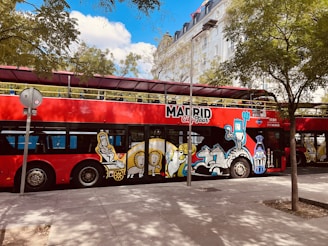 A red double decker bus parked on the side of the road