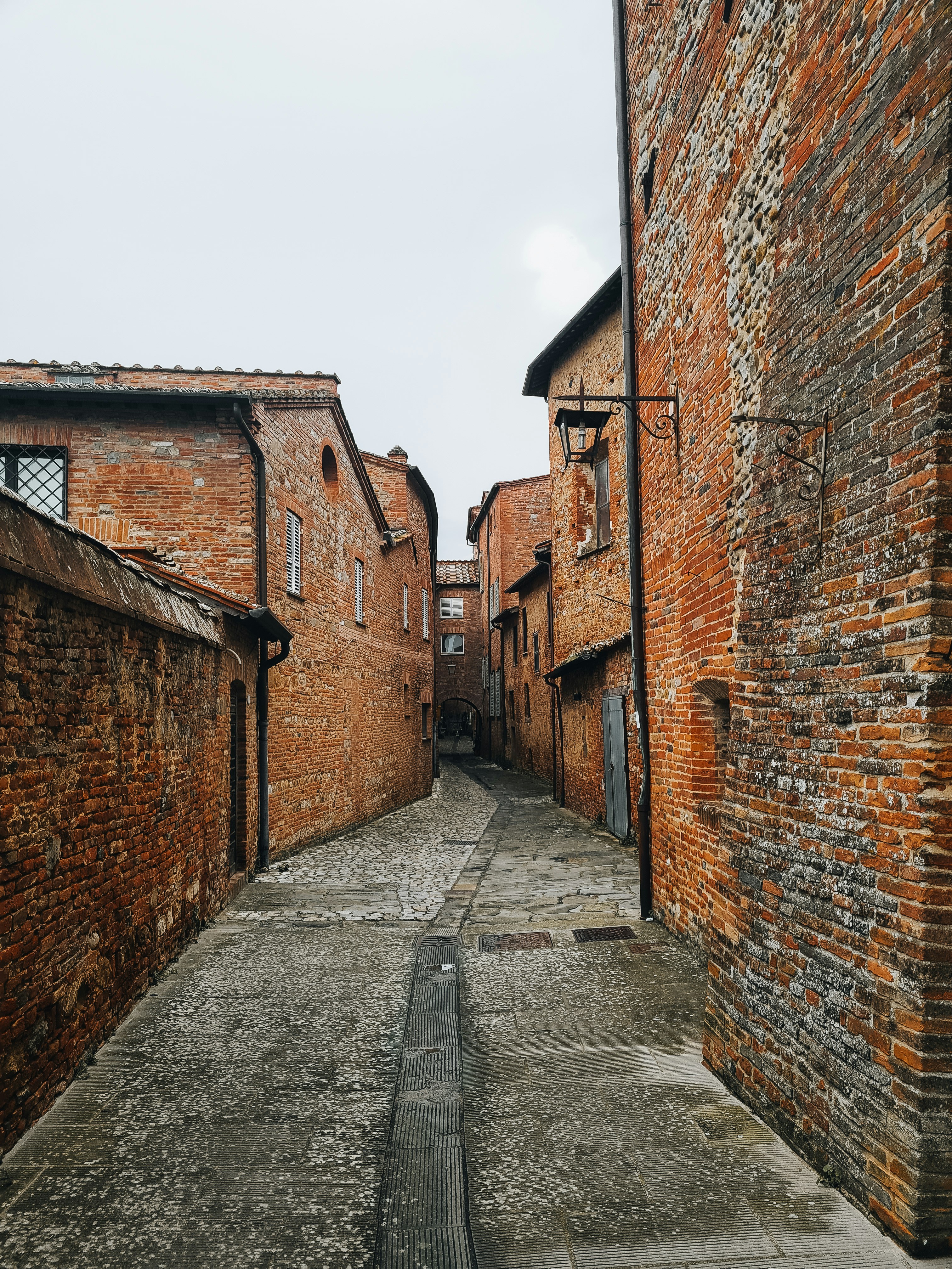 A narrow alley way with brick buildings on both sides