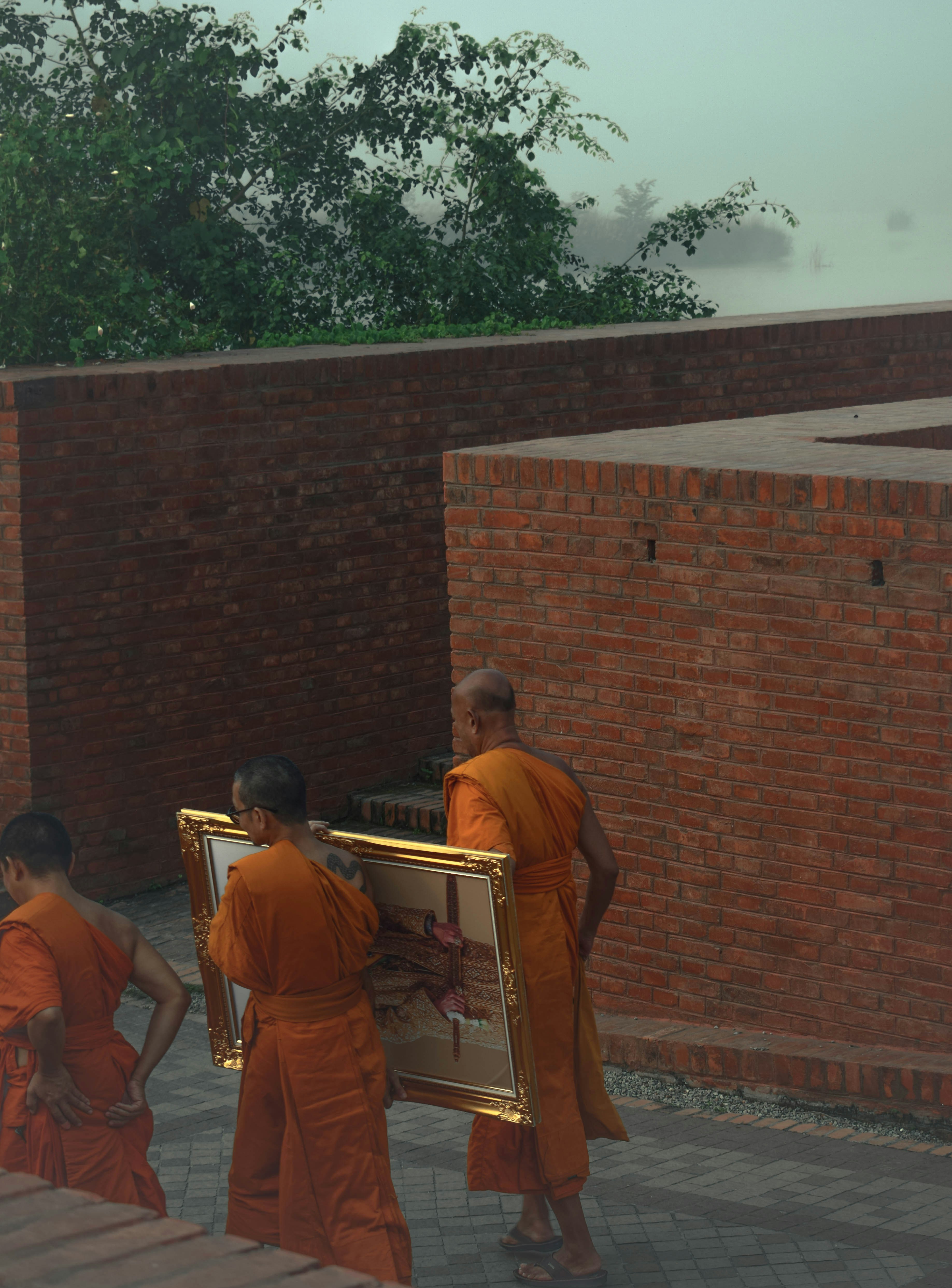 A group of monks carrying a painting in a courtyard