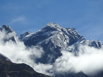 A view of a mountain with clouds in the foreground
