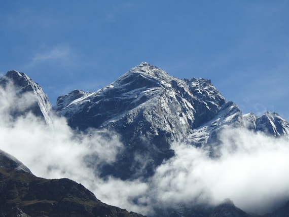 A view of a mountain with clouds in the foreground