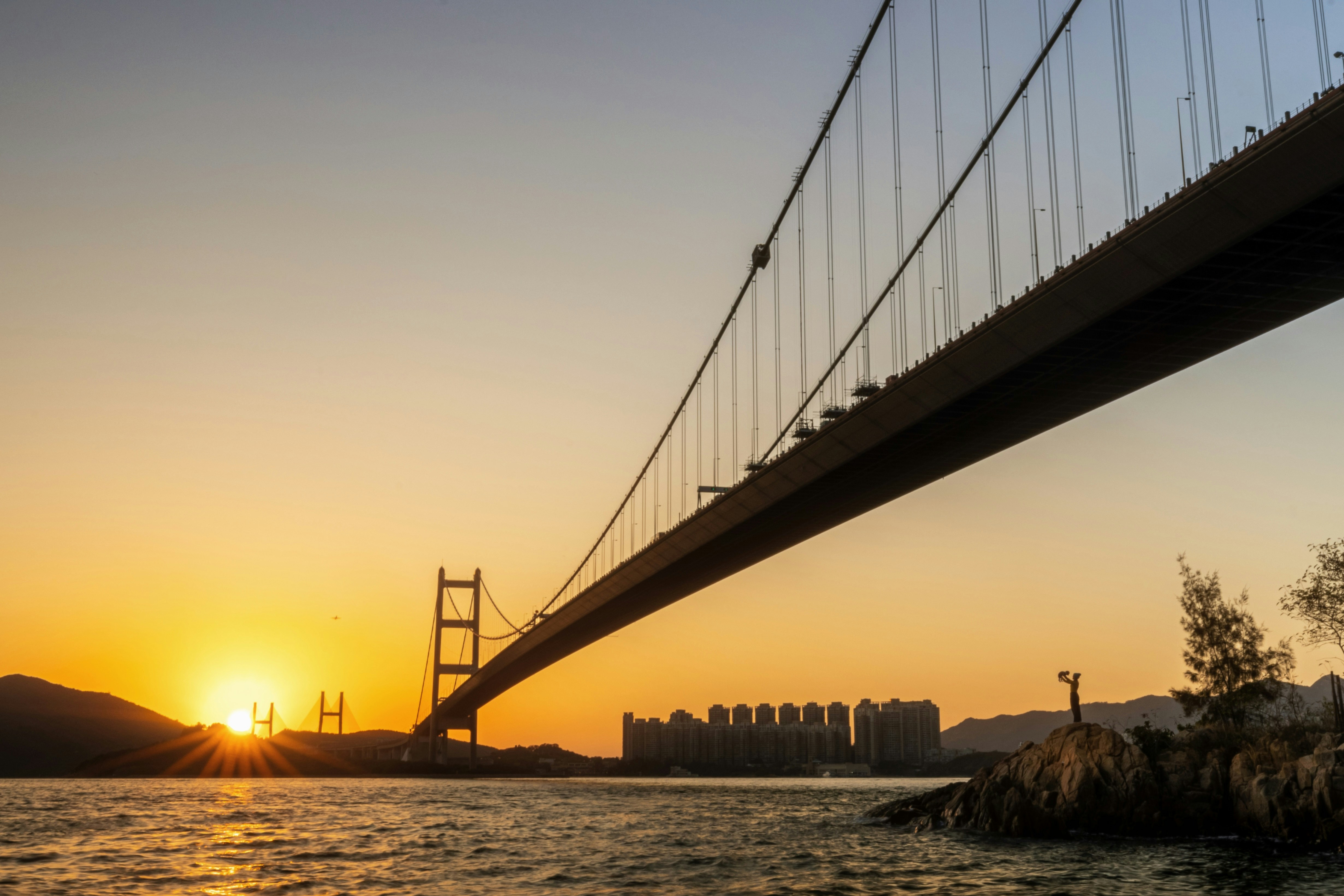 The sun is setting behind the golden gate bridge