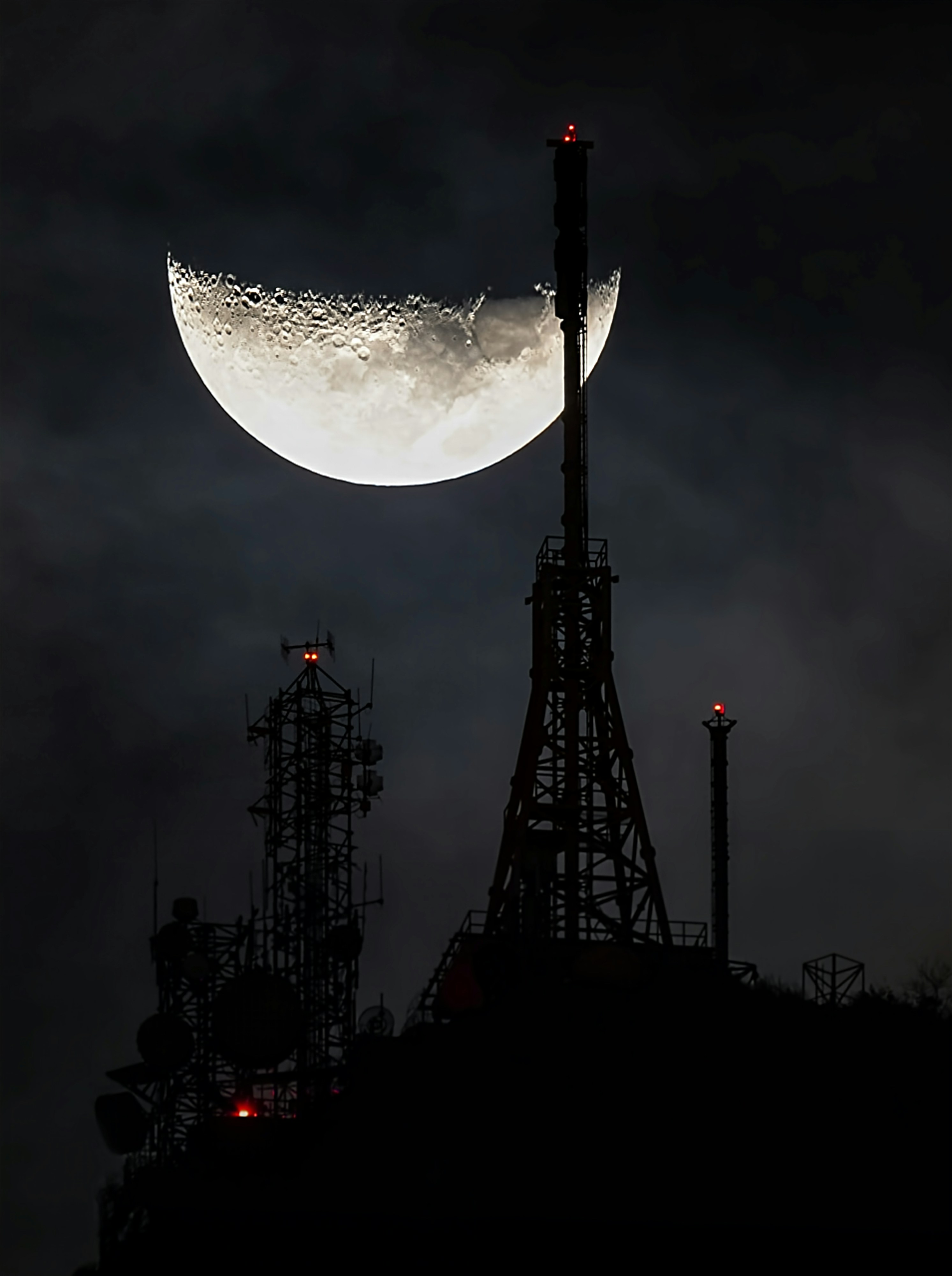 The moon is seen over the top of a building