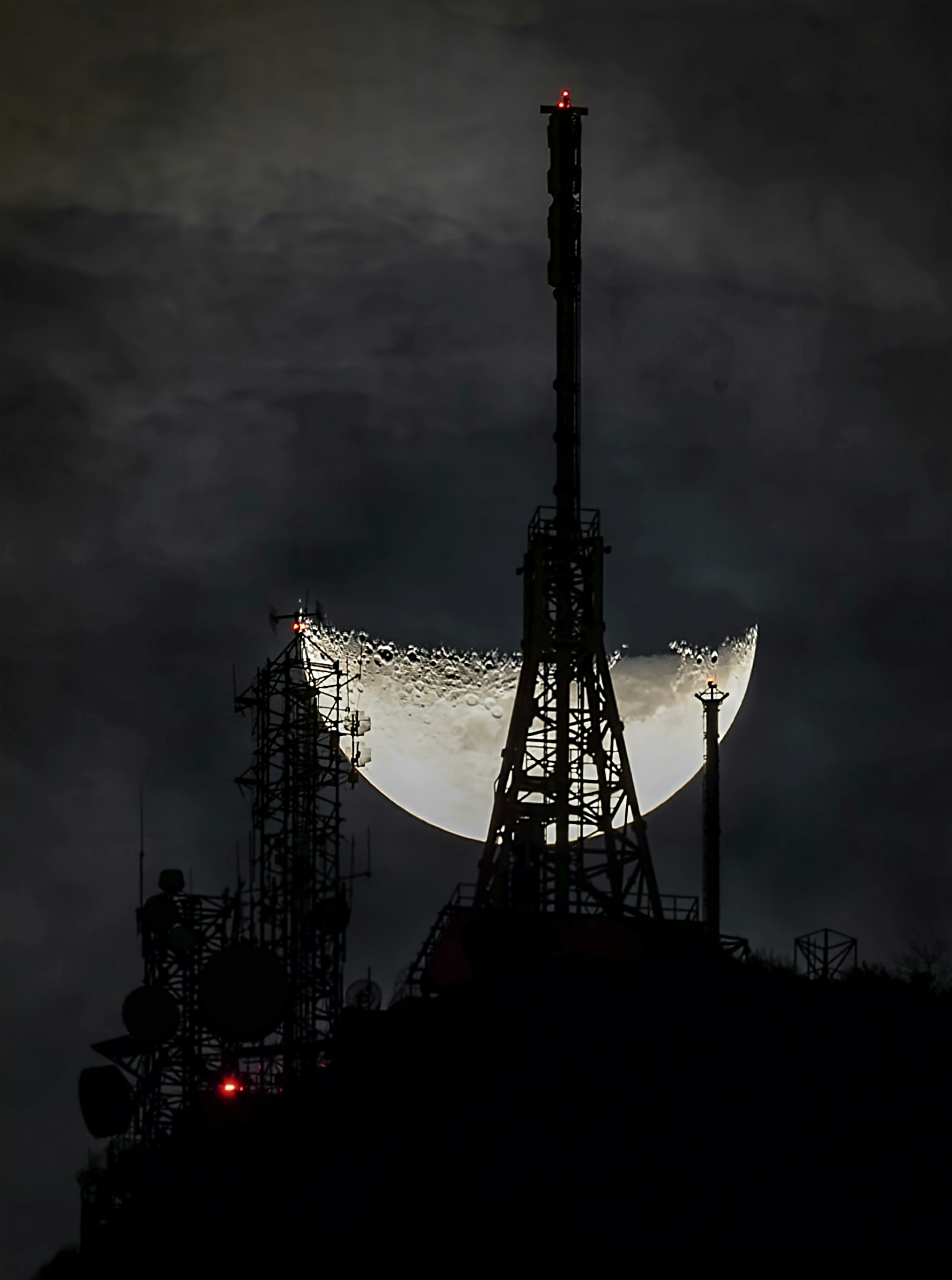 A full moon is seen behind an oil rig