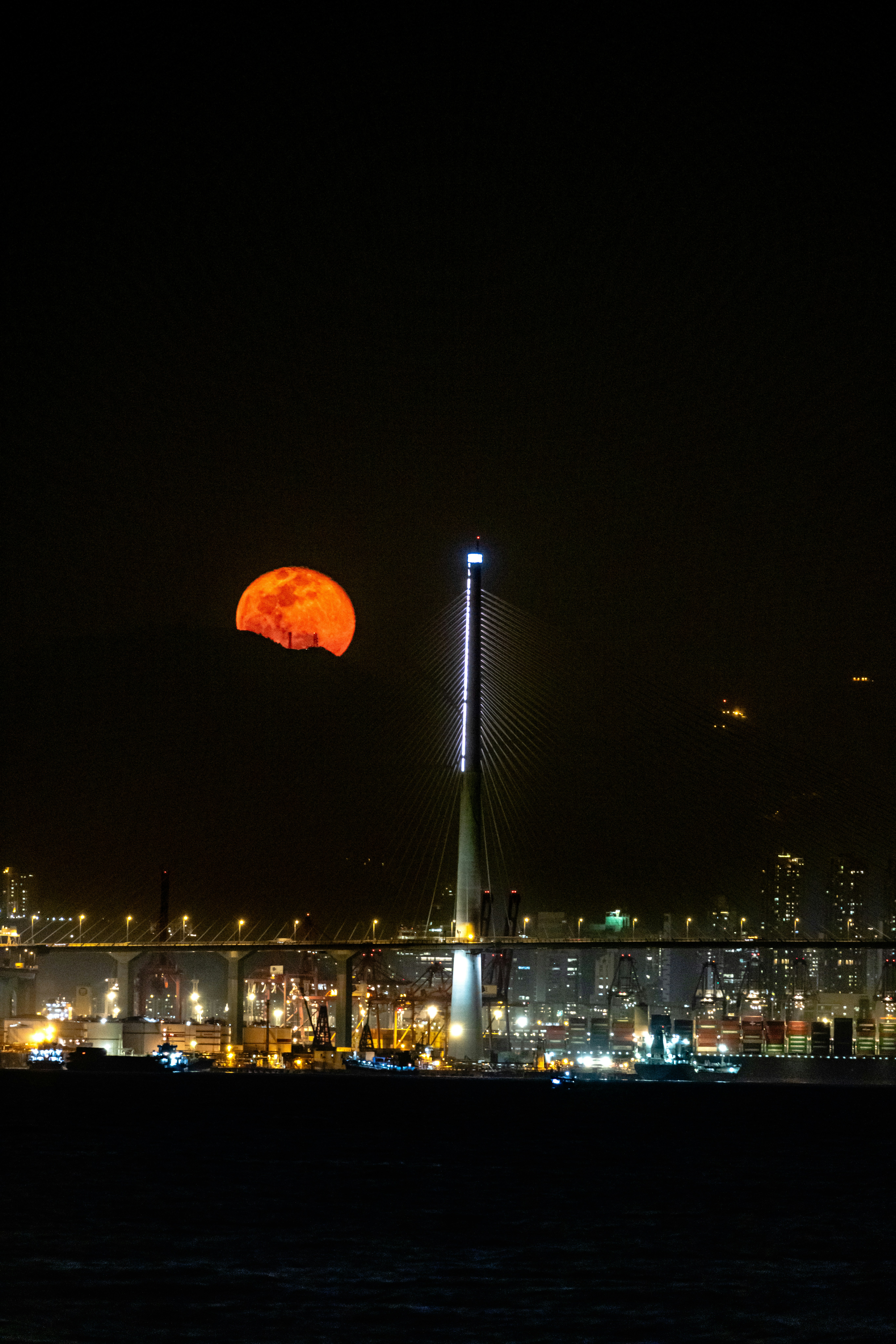 A full moon is seen over a city at night