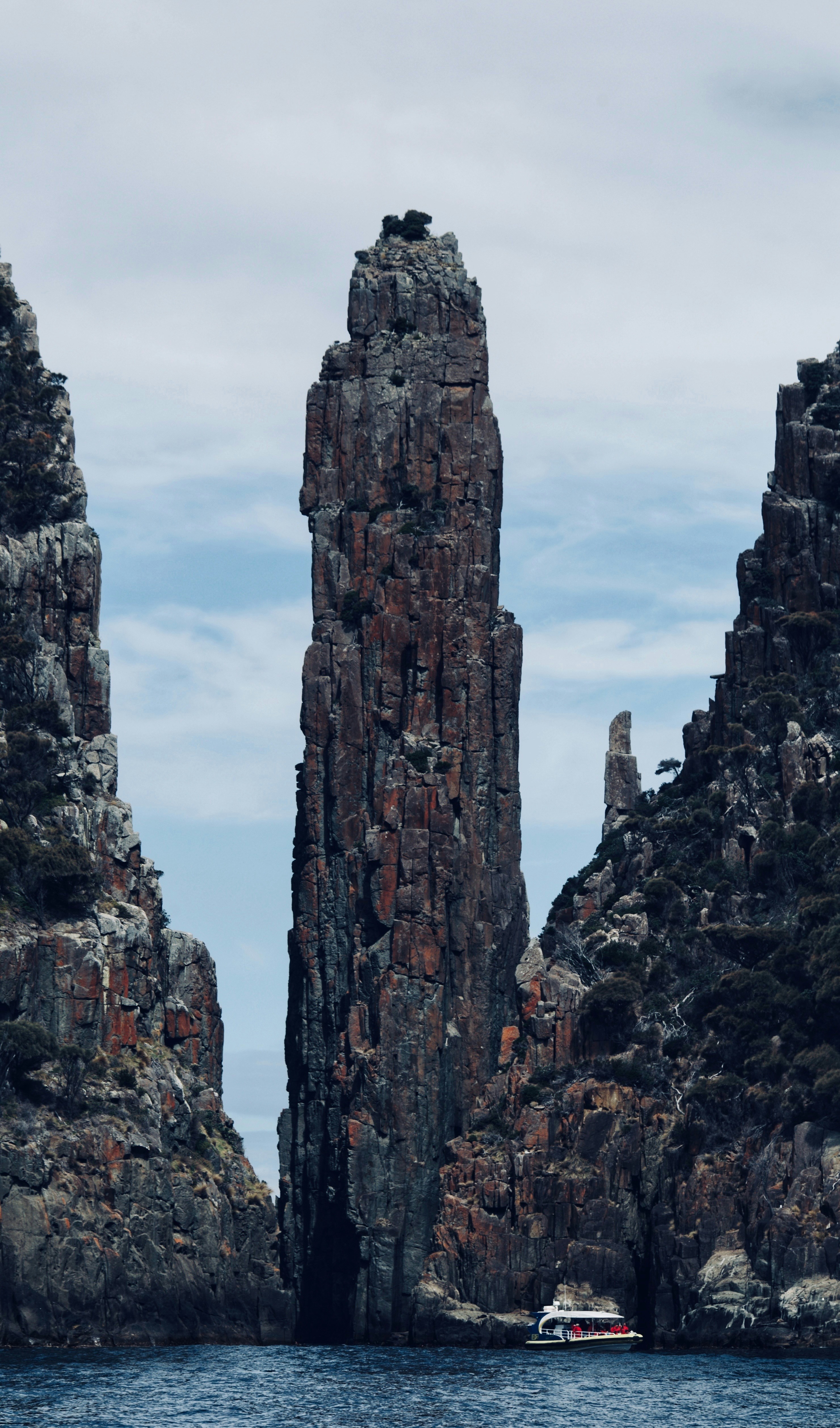 A boat is in a body of water near some rocks