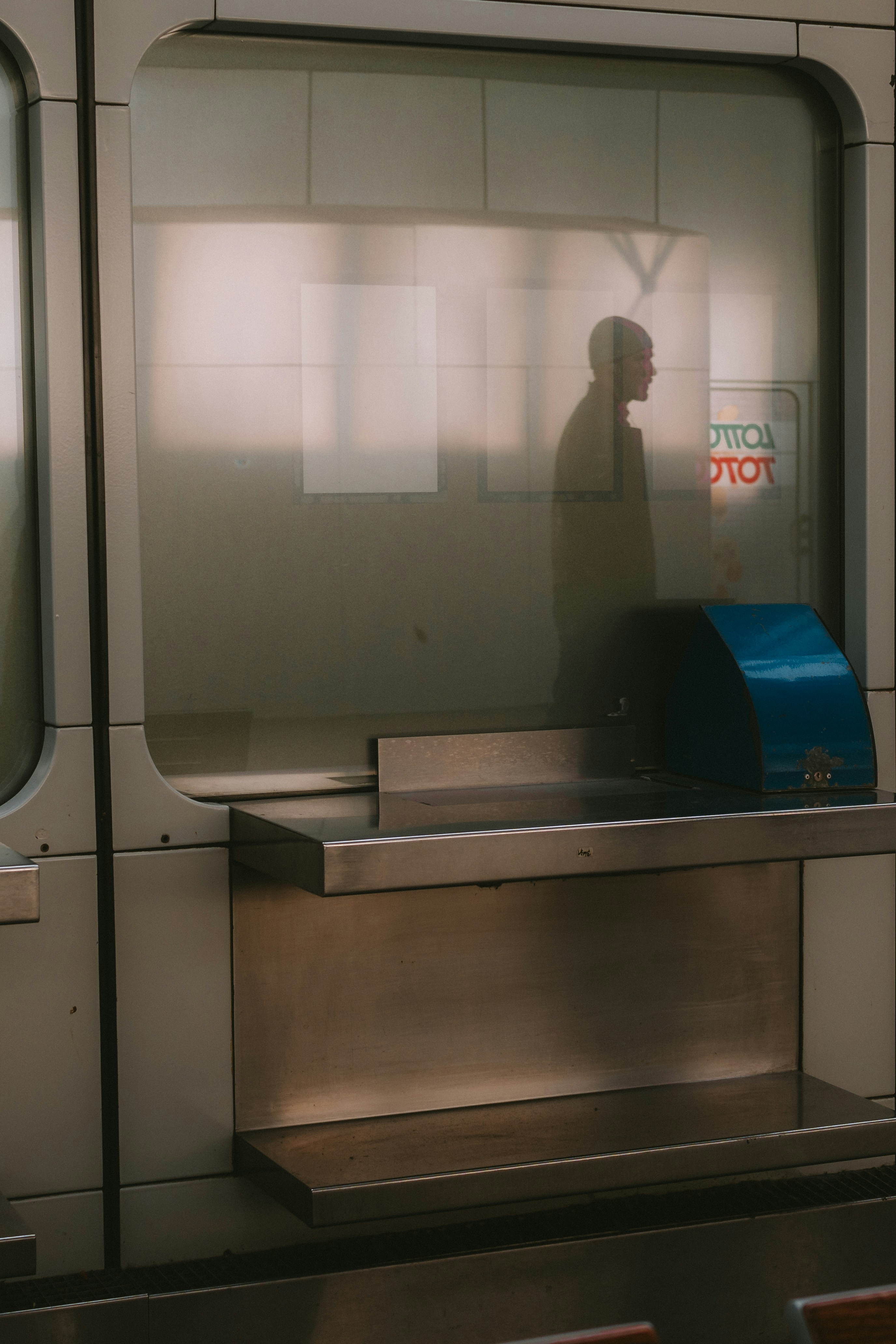 A man standing in front of a window next to a bench