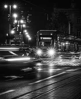 A black and white photo of a city street at night