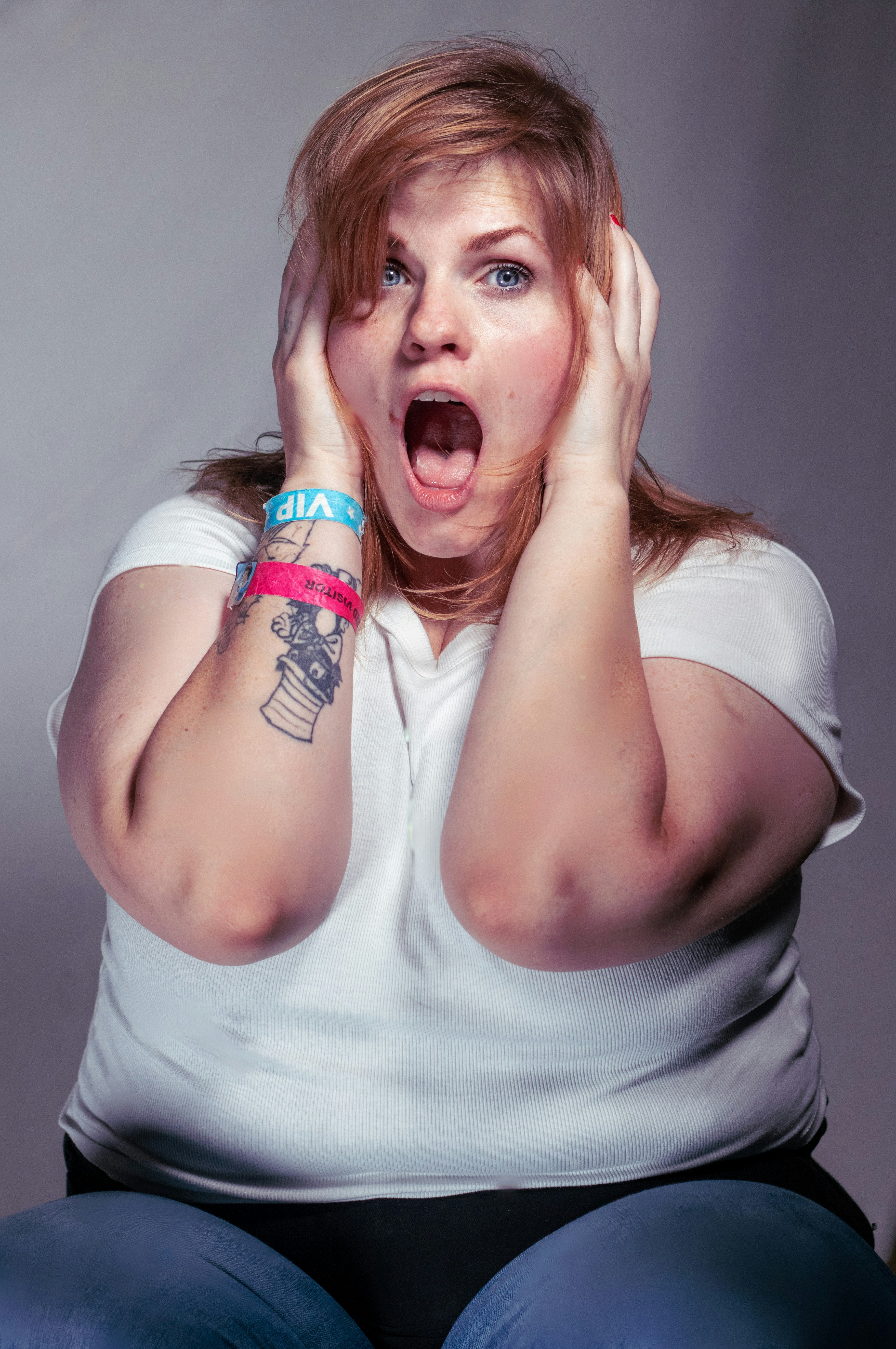 A woman sitting on the floor with her hands on her face