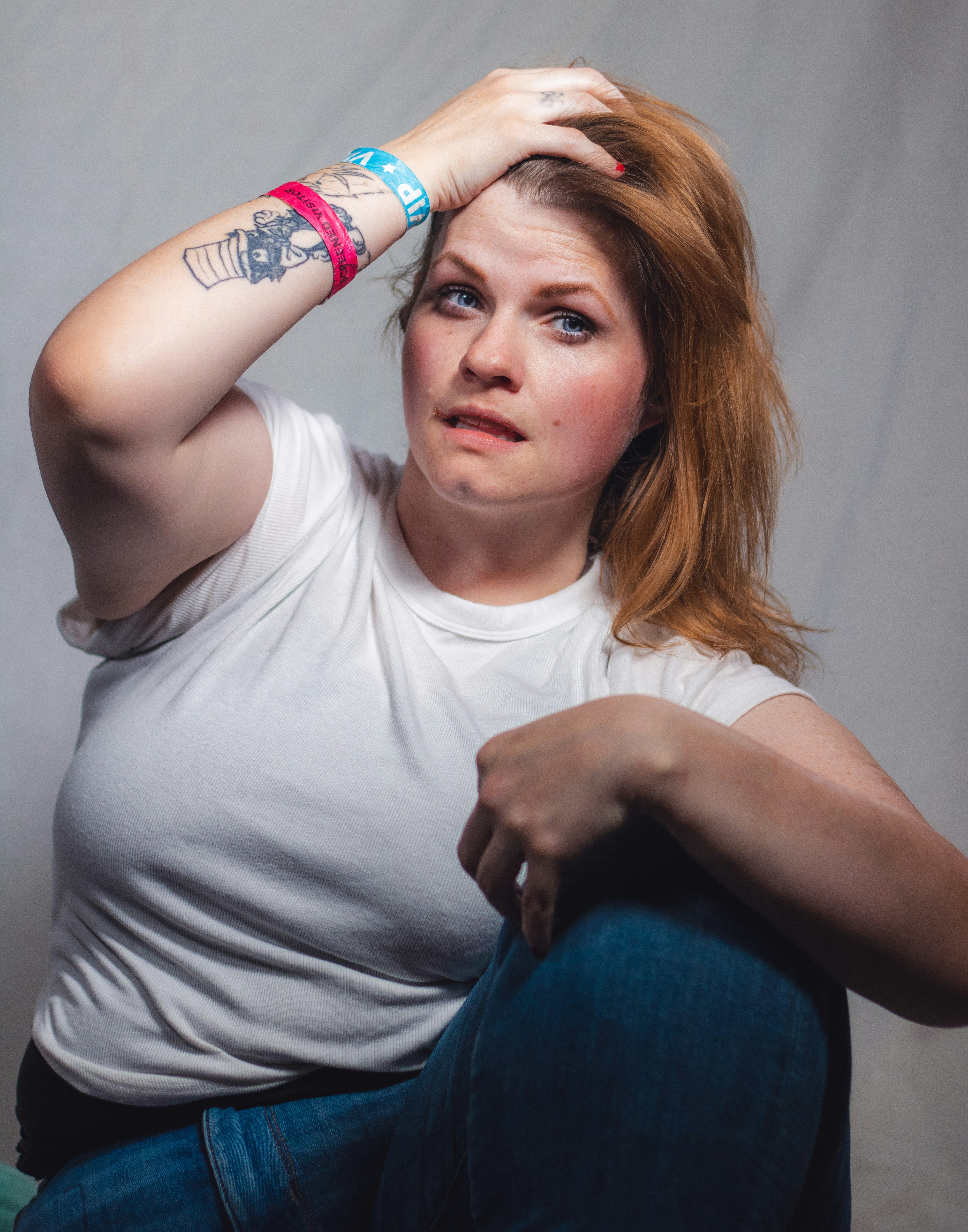 A woman sitting on a chair with a tattoo on her arm