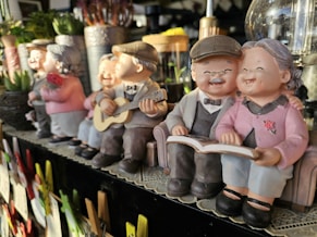A row of little figurines sitting on top of a shelf