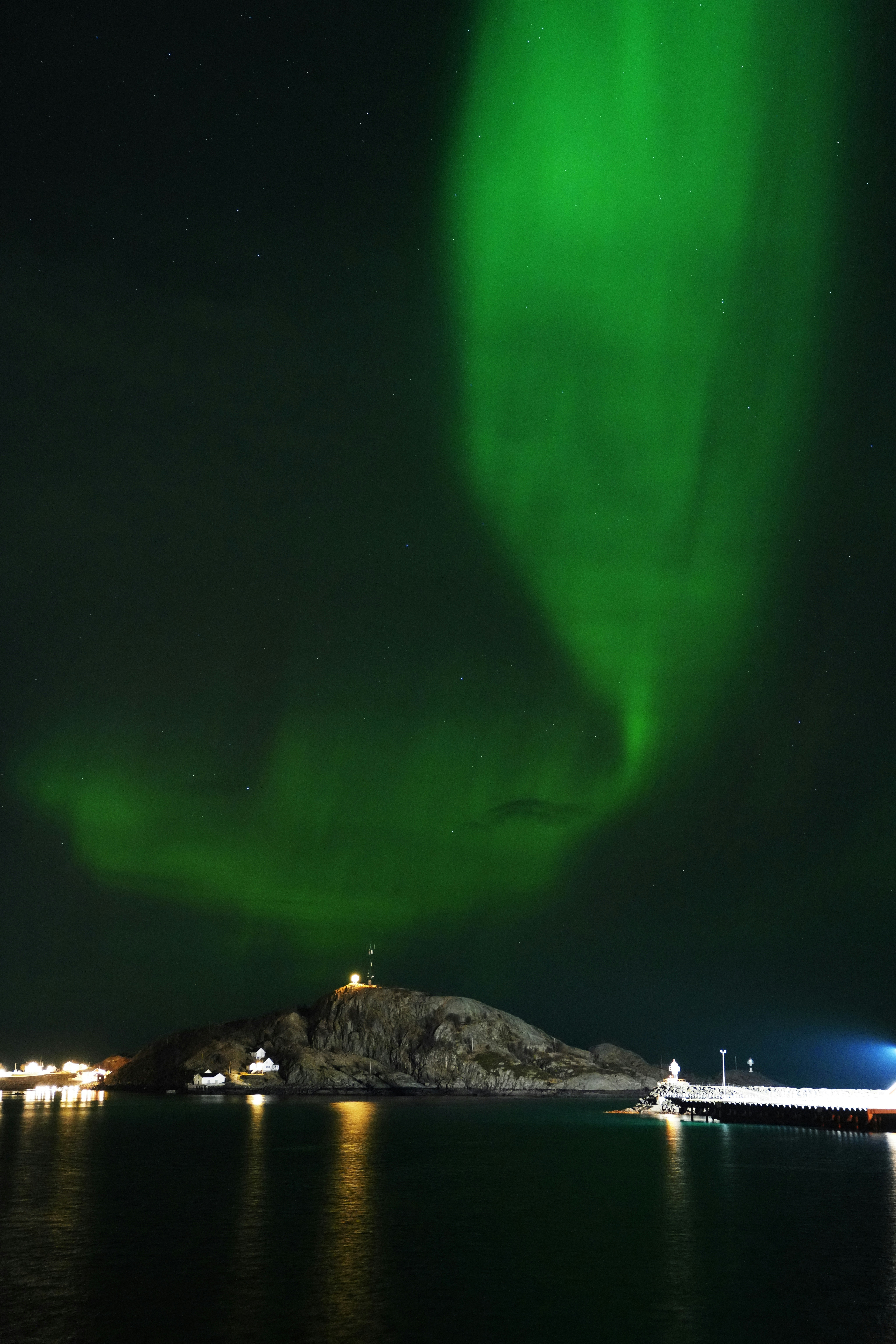 Uma aurora verde brilhante sobre um corpo de água