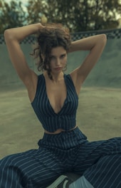 A woman sitting on the ground with her hands behind her head
