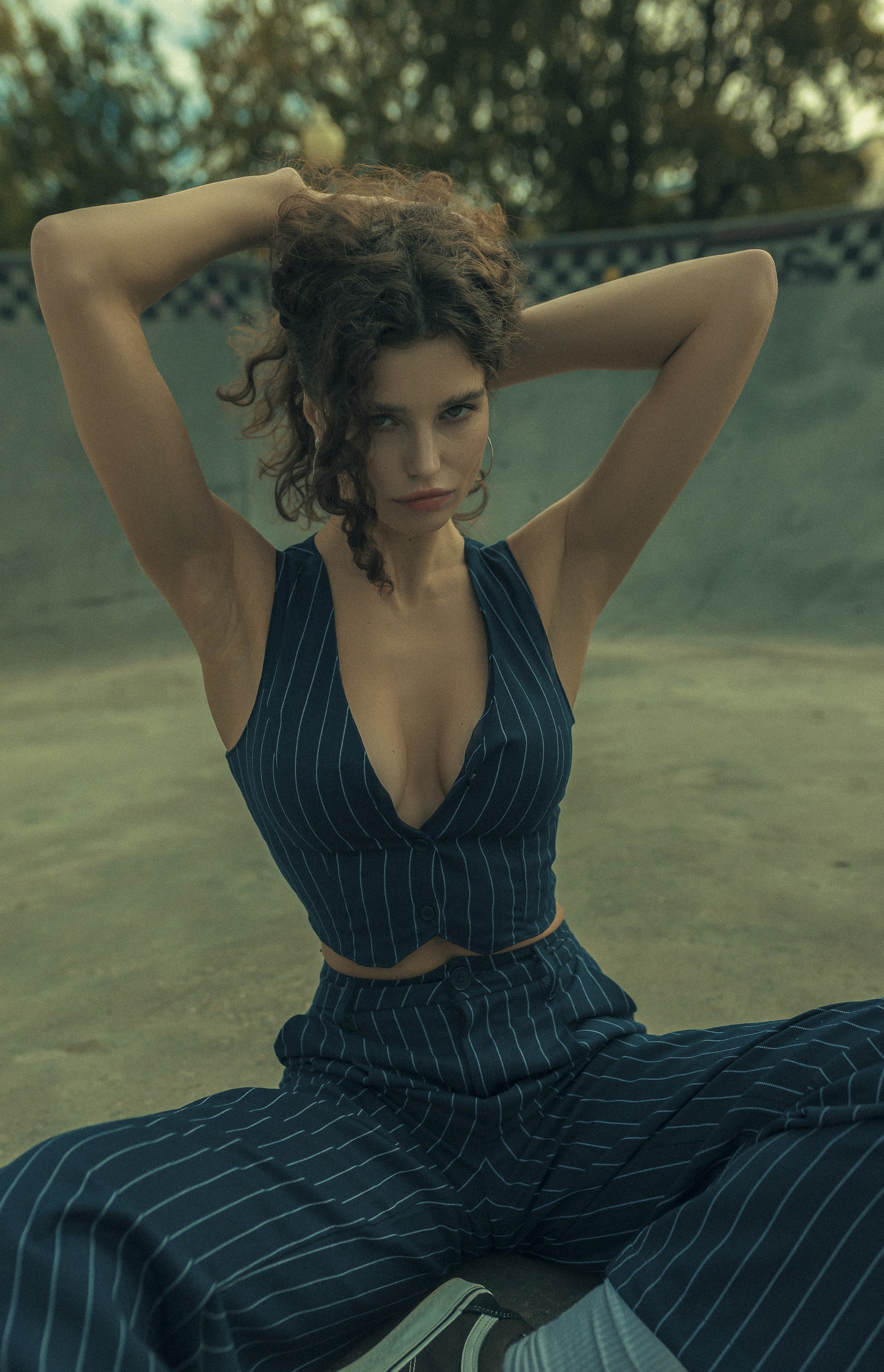 A woman sitting on the ground with her hands behind her head