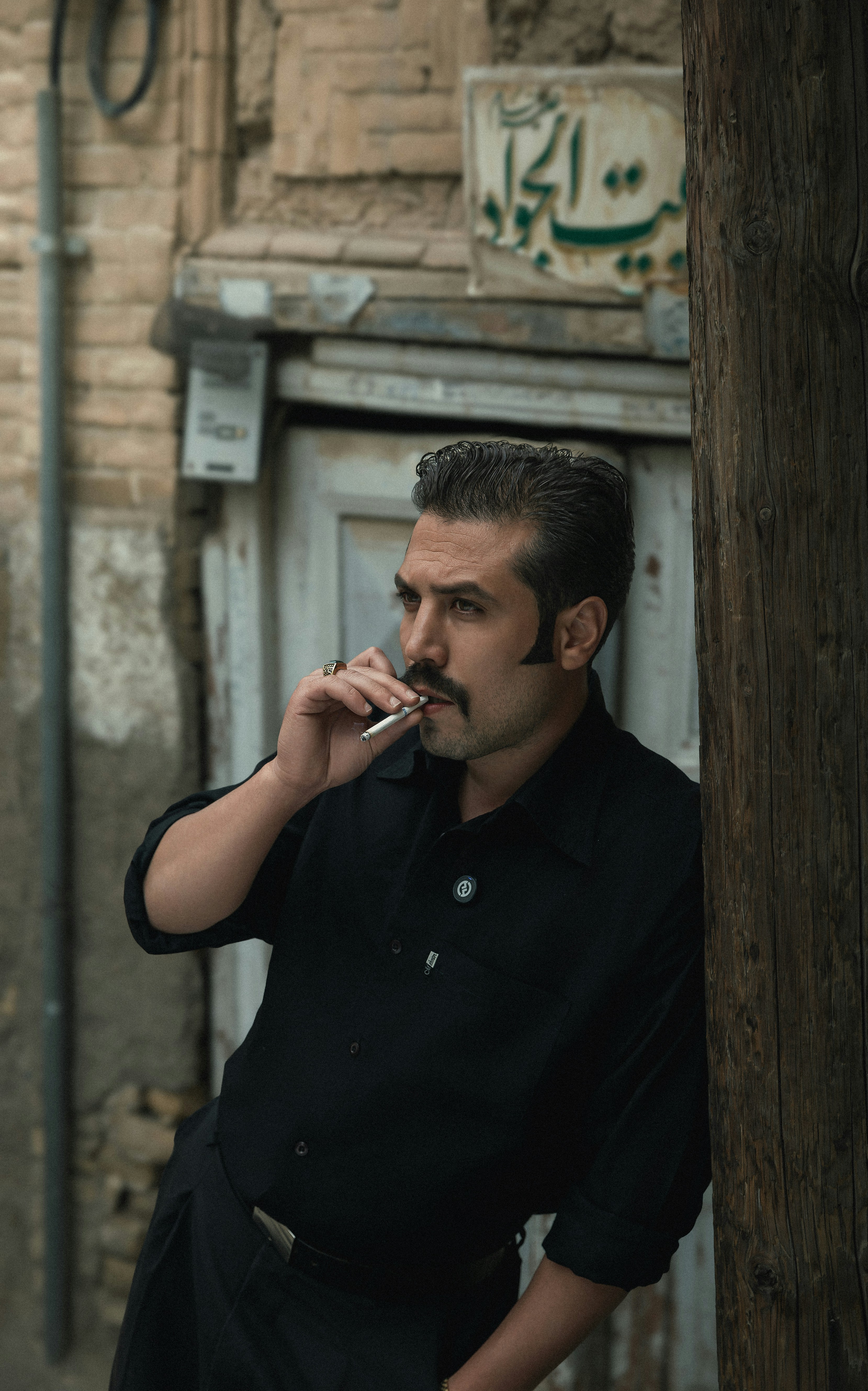A man smoking a cigarette in front of a building