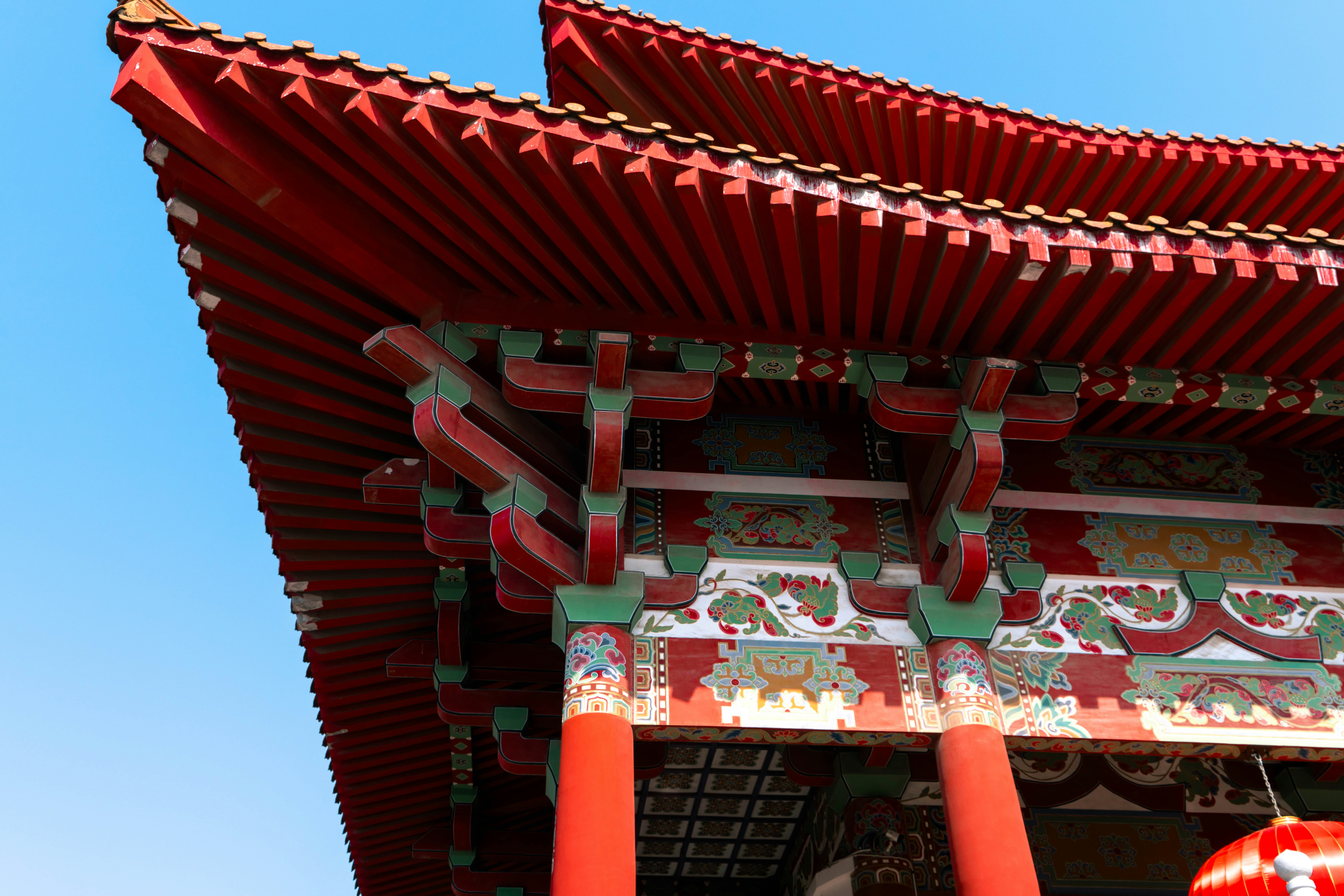 A tall red building with a red lantern hanging from it's side