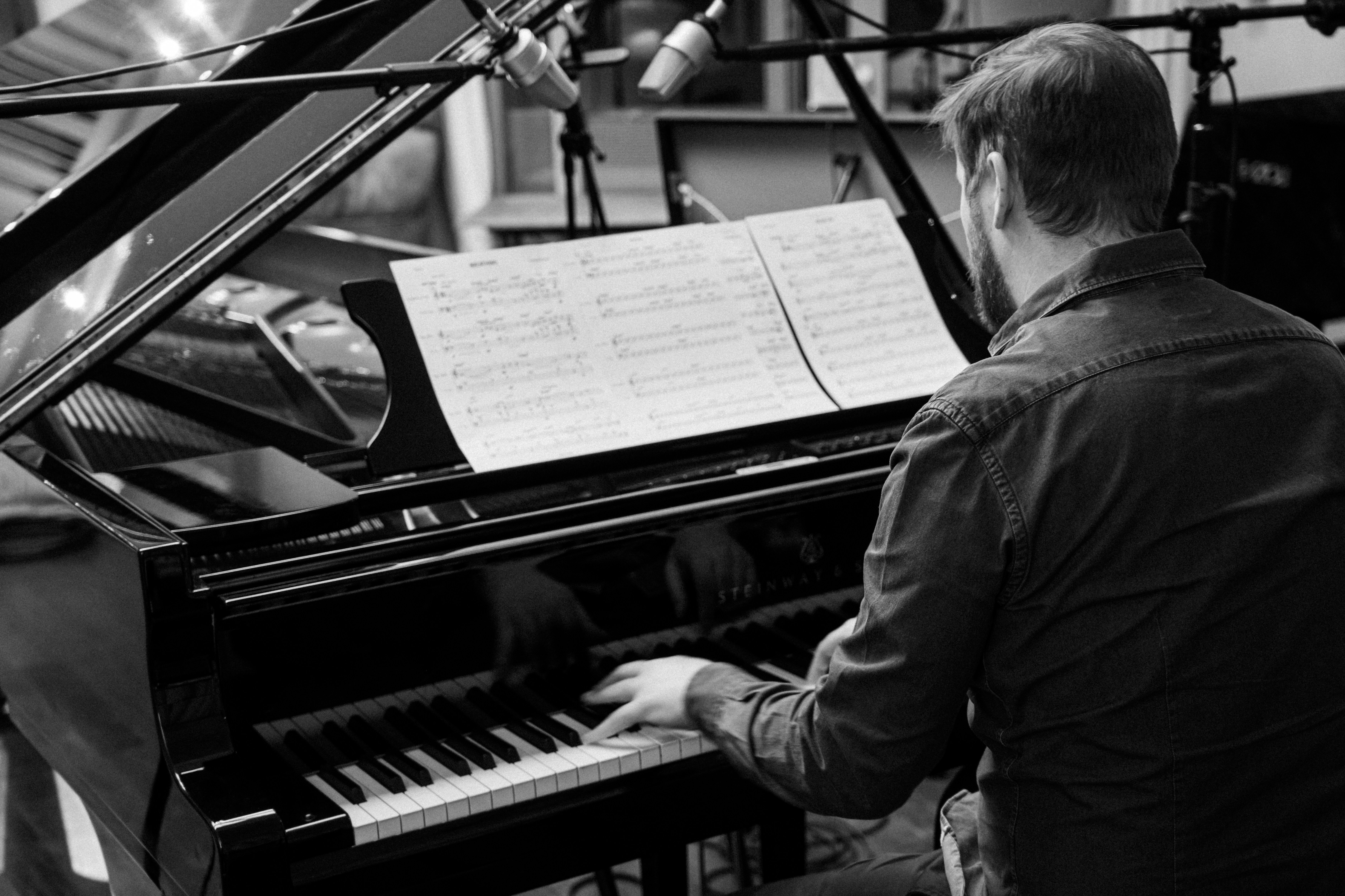 A man playing a piano in a recording studio