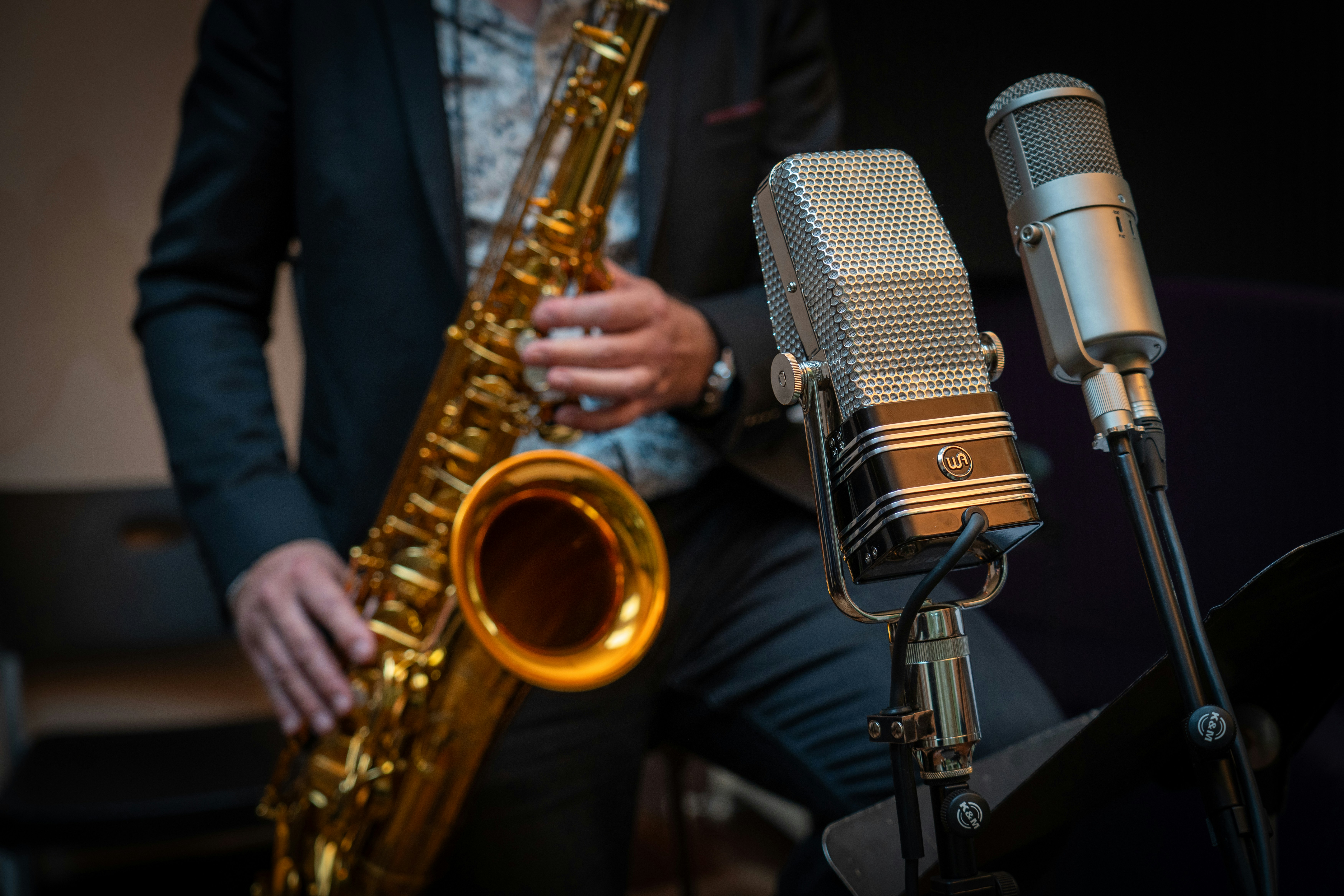 A man playing a saxophone in front of a microphone