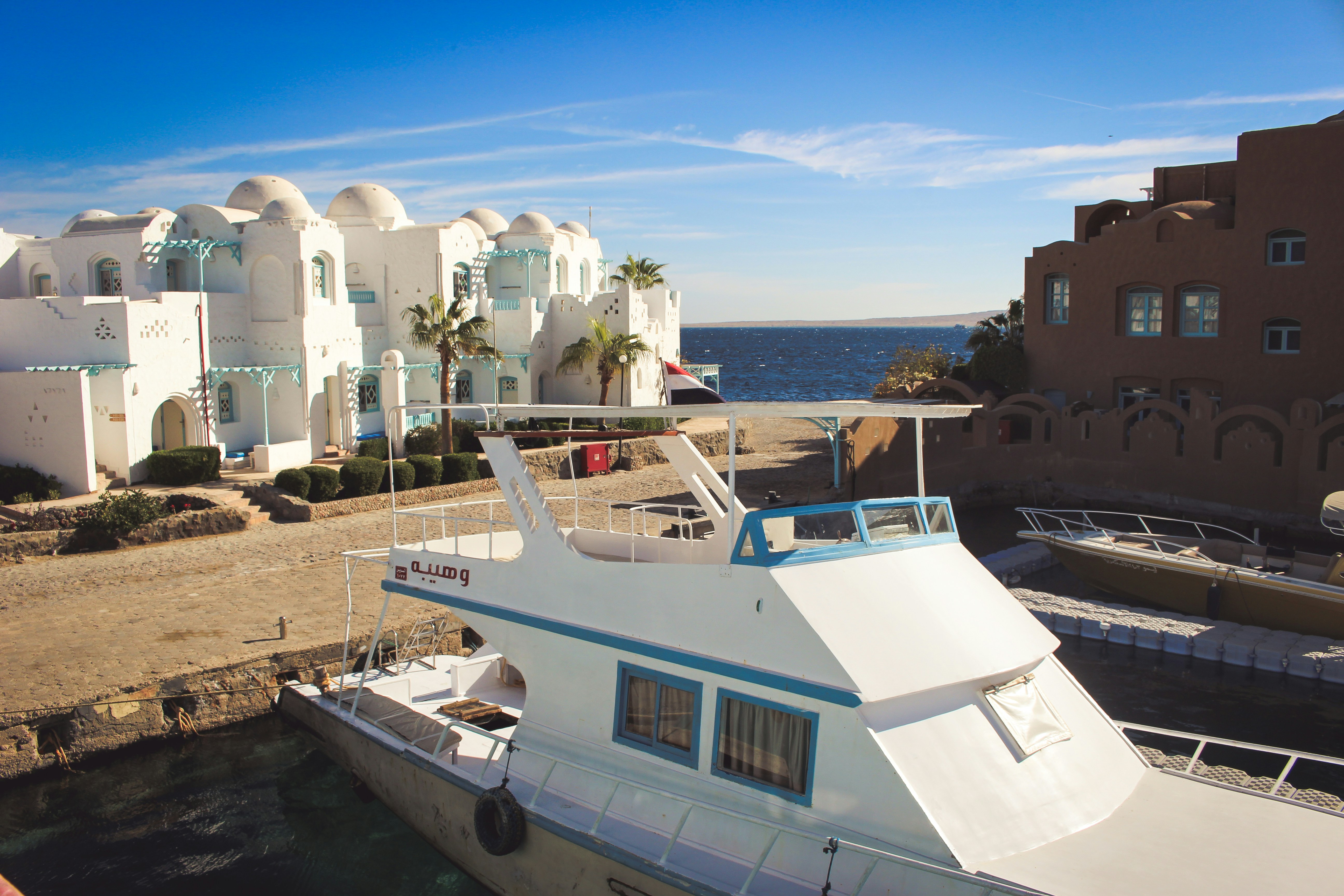 A white boat is docked at a dock