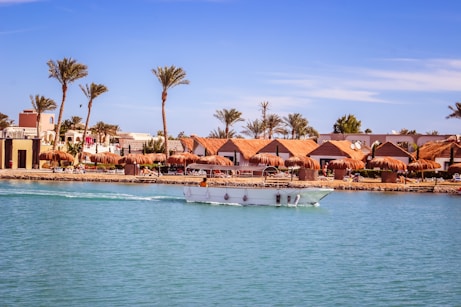 A boat traveling down a river next to a beach