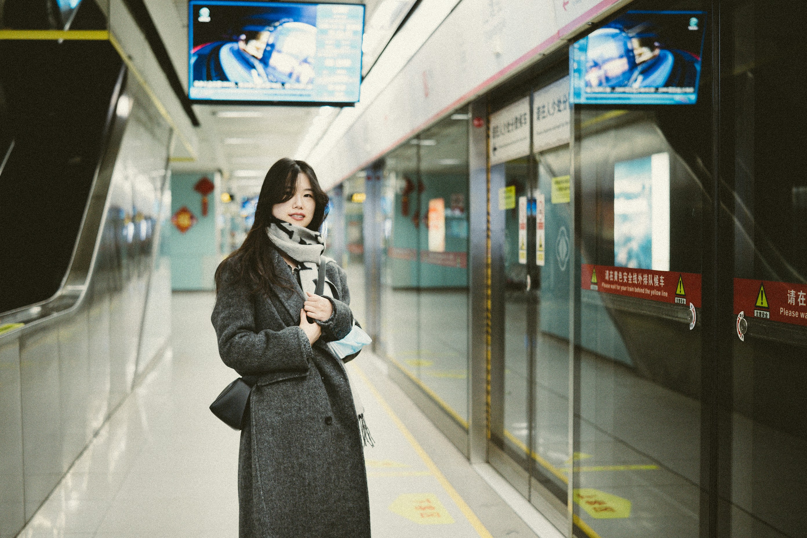 A woman is standing in a subway station