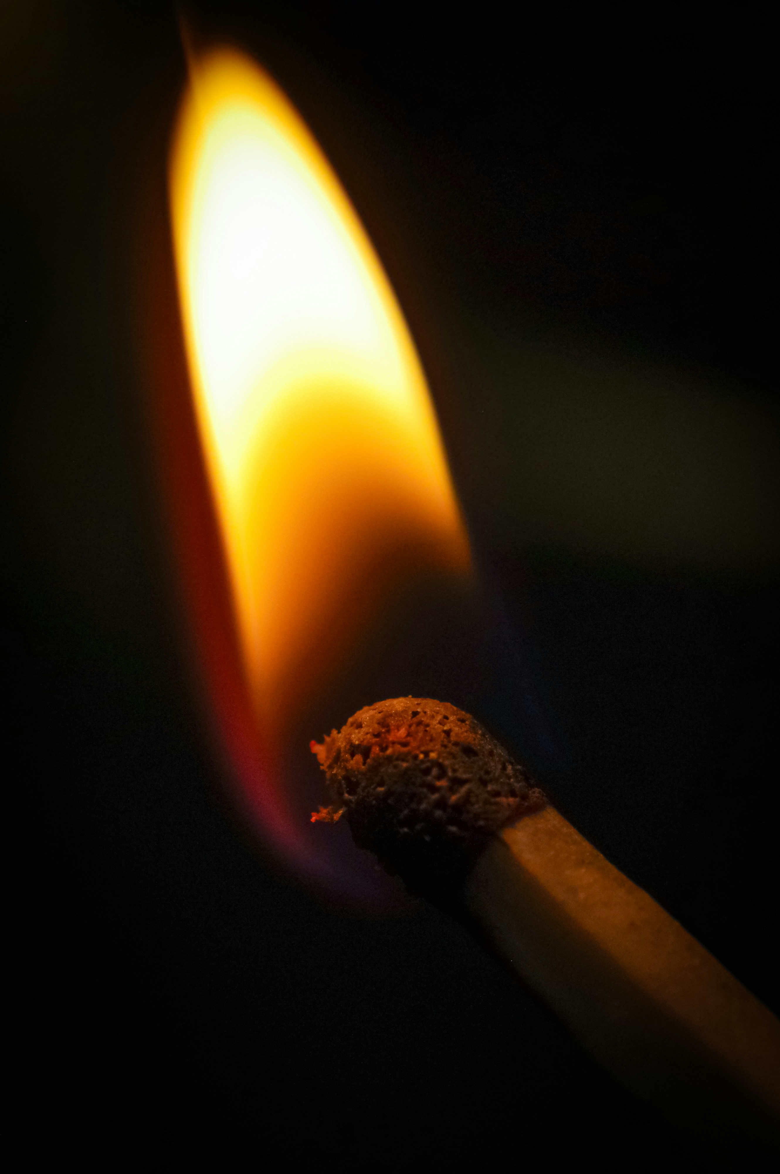 Una cerilla con una cerilla encendida sobre un fondo negro