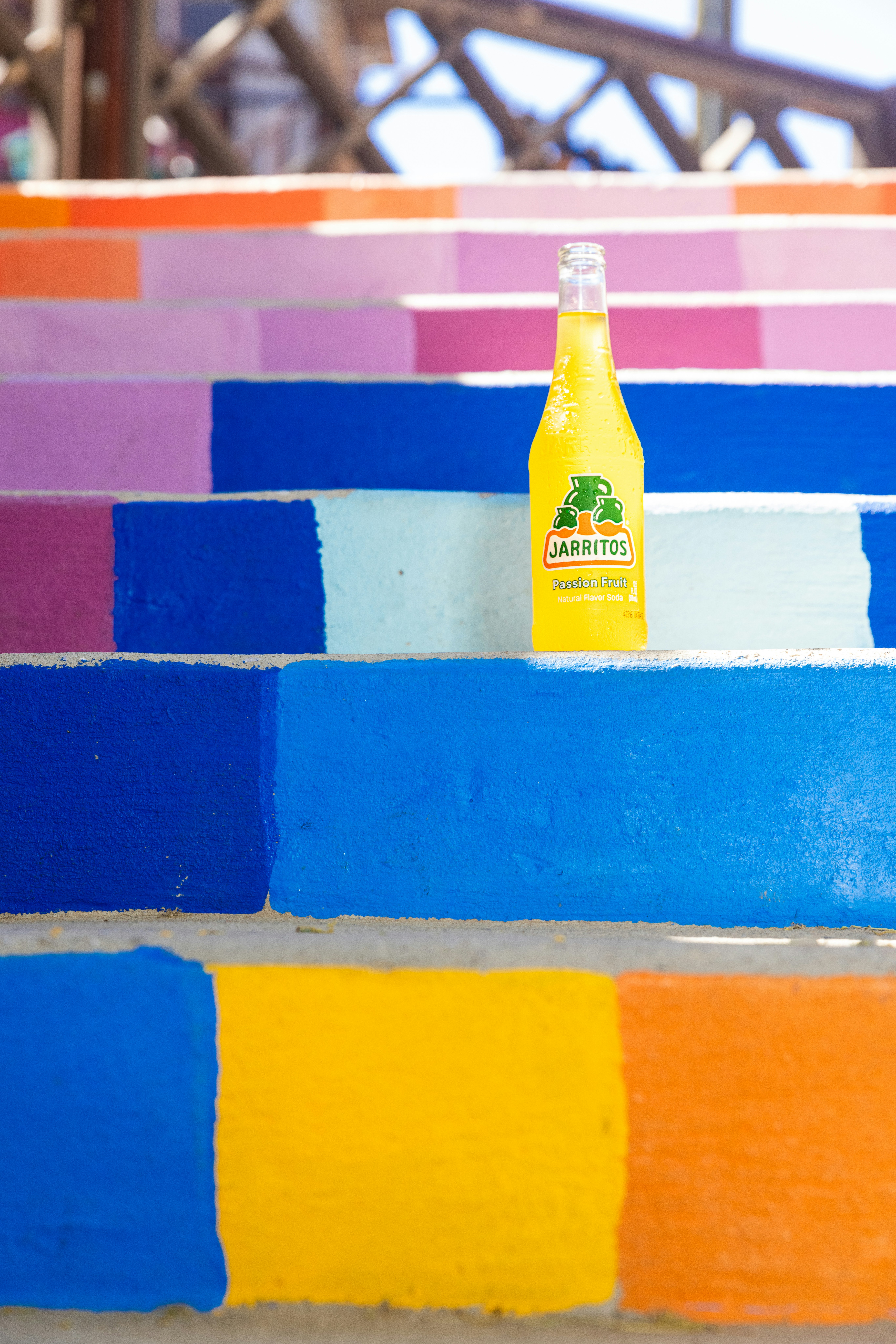 A bottle of orange juice sitting on top of colorful steps