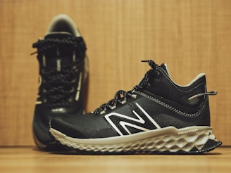 A pair of new balance shoes on a wooden floor