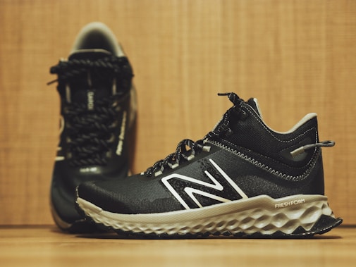 A pair of new balance shoes on a wooden floor