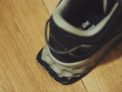 A pair of black and white shoes sitting on top of a wooden floor