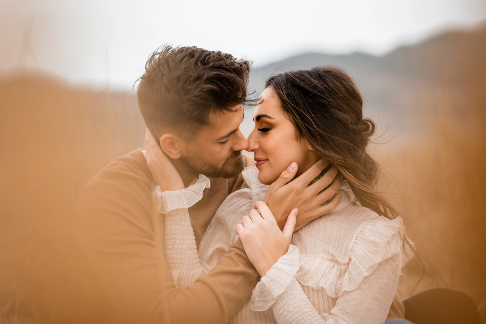 A man and a woman embracing in a sunlit field
