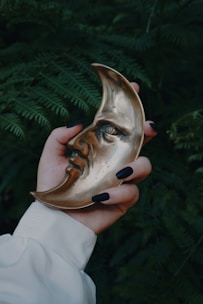 A woman holding a golden mask in her hand