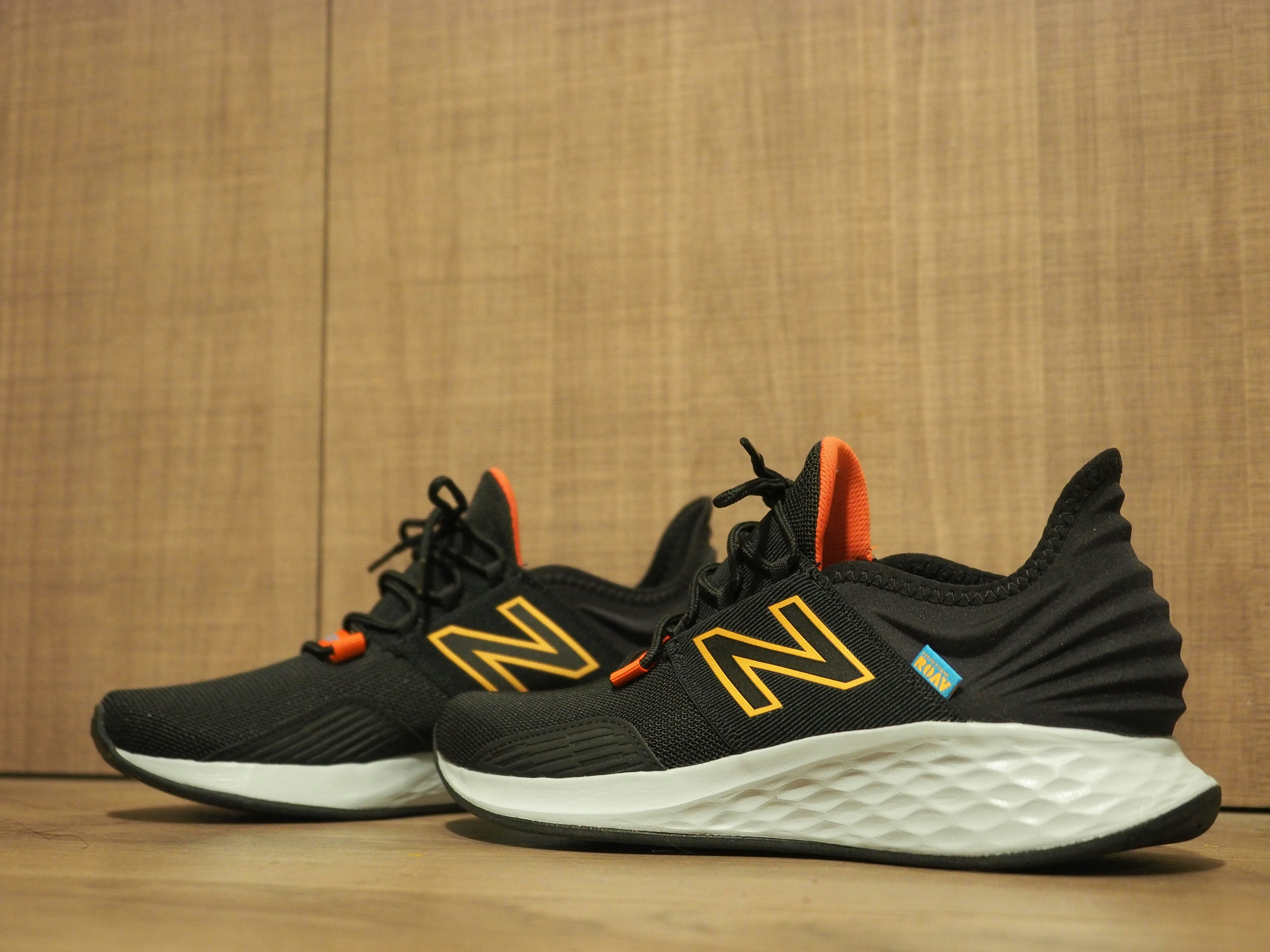 A pair of new balance shoes on a wooden floor